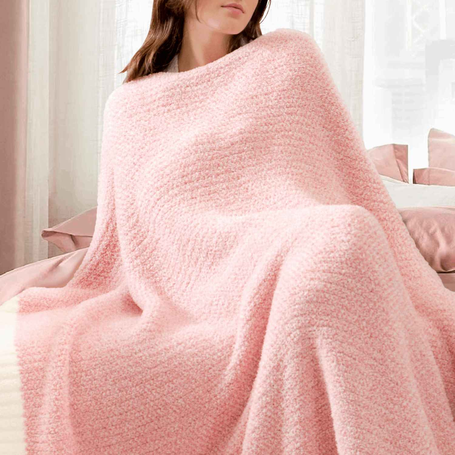 A woman wrapped in Snuggle Sac Heather Feather Yarn Pink Knit Throw Blanket #Color_Pink