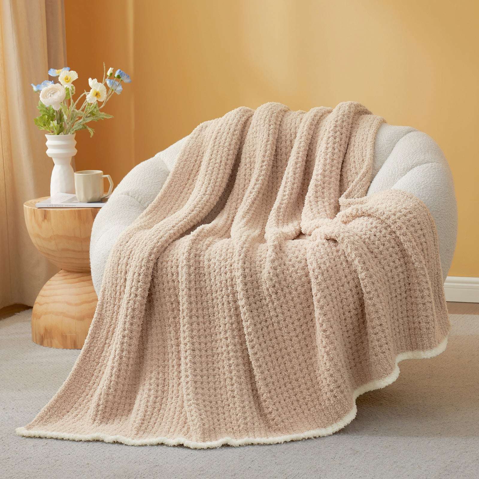 Soft Waffle Feather Yarn Knit Throw Blanket on a beige chair with vase of flower and mug #Color_Beige