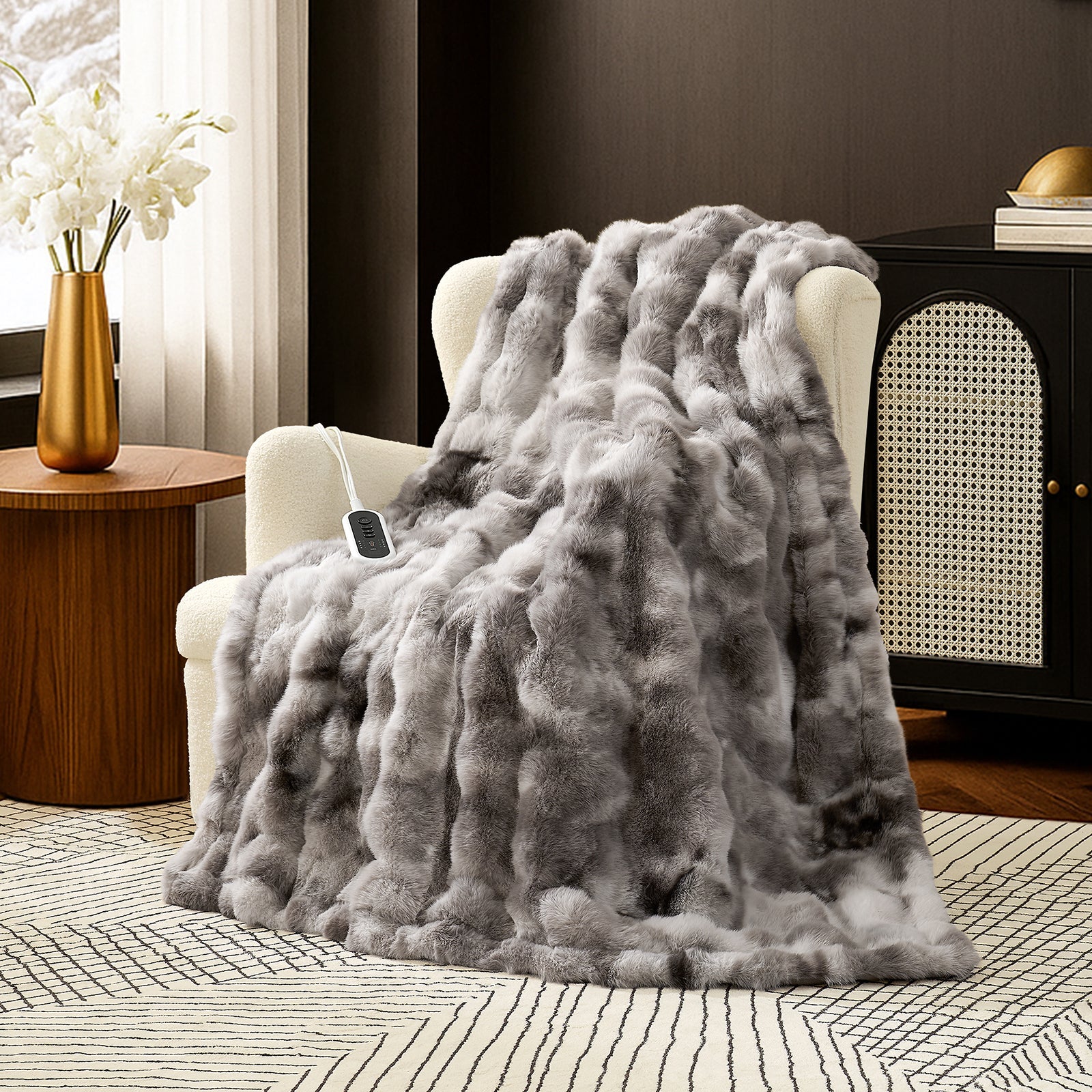 Snuggle Sac bubble faux fur electric blanket in Tie-dye Taupe draped over a chair with controller, creating a warm and cozy setting #color_Tie-dye Taupe