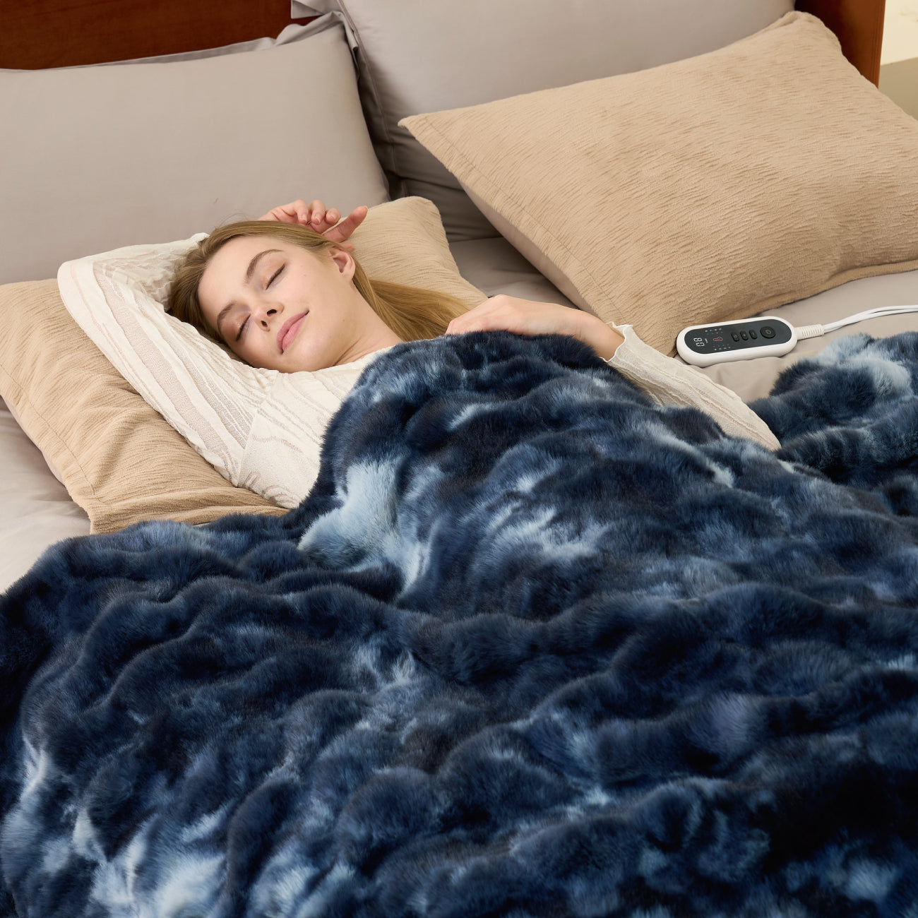 Woman sleeping under a Snuggle Sac bubble faux fur electric blanket in Tie-dye Blue for soothing and consistent warmth #color_Tie-dye Blue