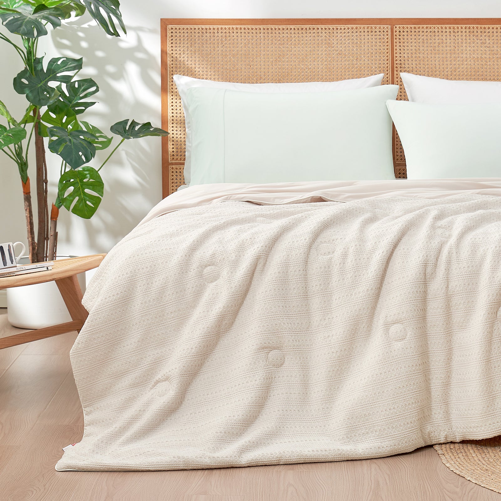 Snuggle Sac Cooling comforter in beige on bed in a bedroom with plants#color_Beige