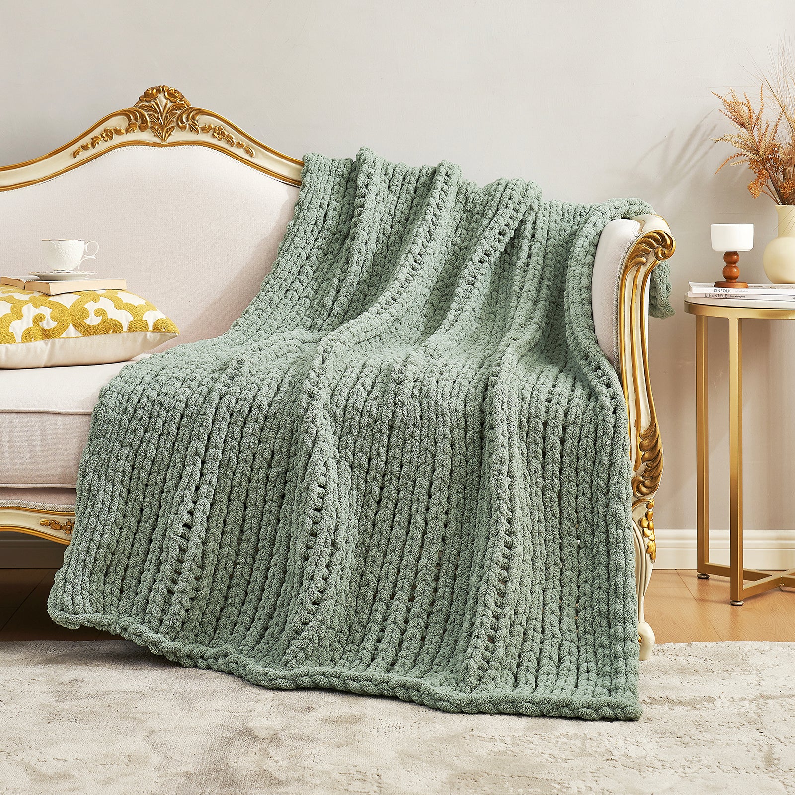 Textured chunky knit throw blanket in Sage Green elegantly spread over a sofa #color_Sage Green