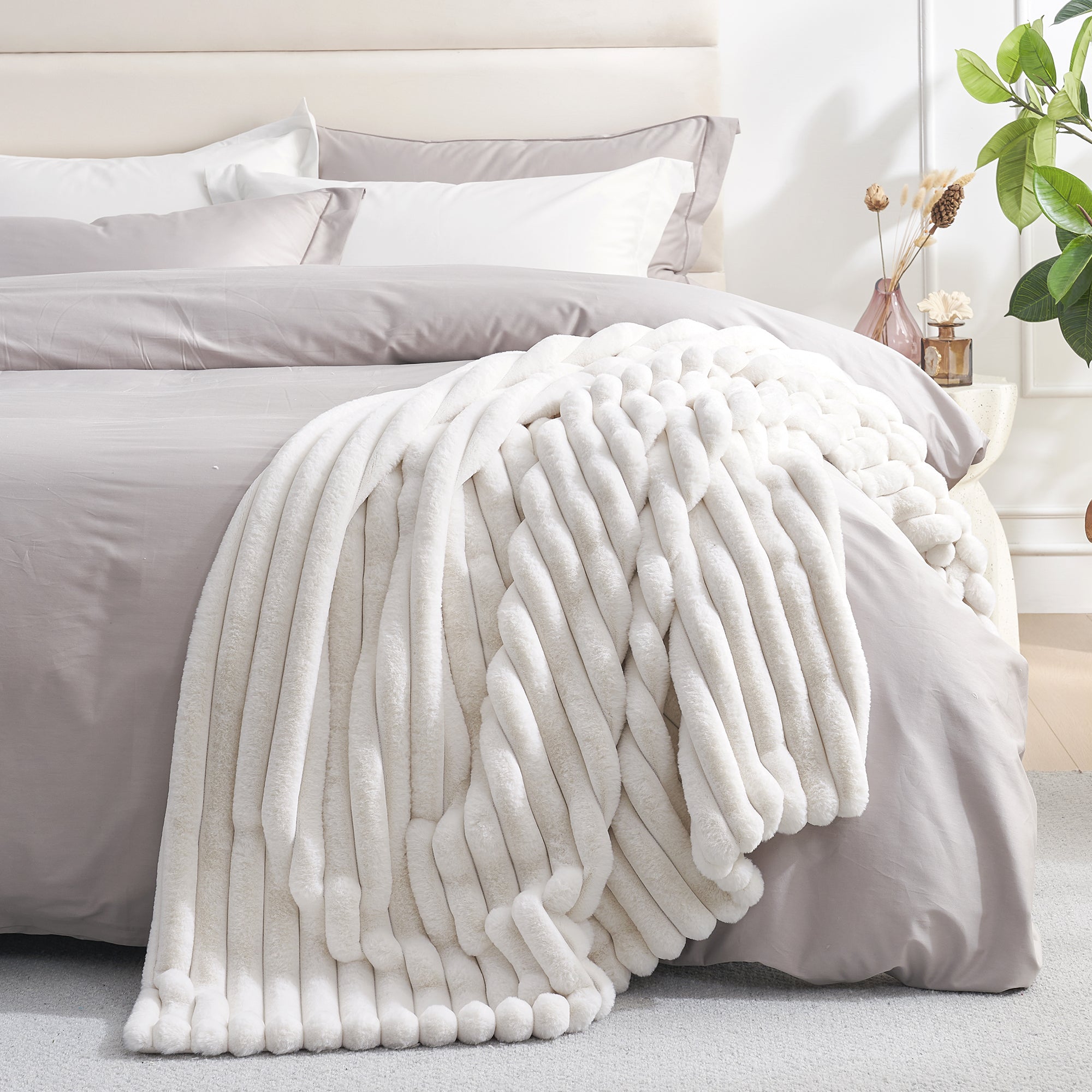 Striped faux fur throw blanket in Ivory layered on a bed, creating a warm and inviting bedroom look #color_Ivory