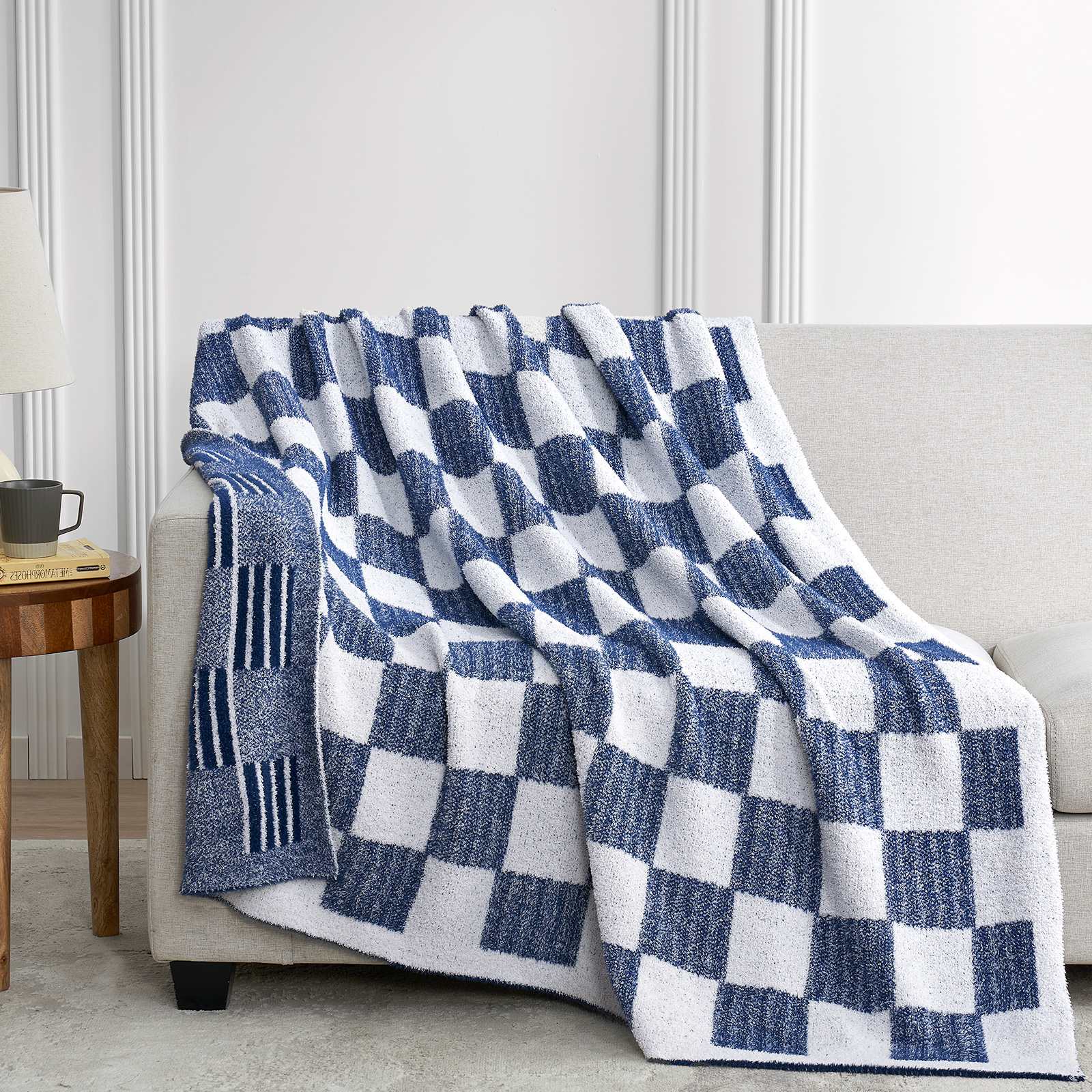Snuggle Sacs Reversible Heather Checkered Feather Yarn Knit Throw Blanket draped on a grey couch#Color_Heather Navy