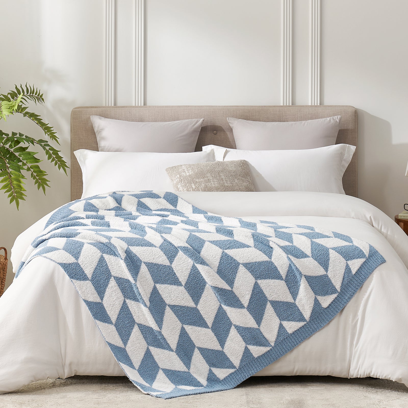 Folded Snuggle Sacs Chevron Feather Yarn Knit Throw Blanket on the bed with plant next to it#color_Blue
