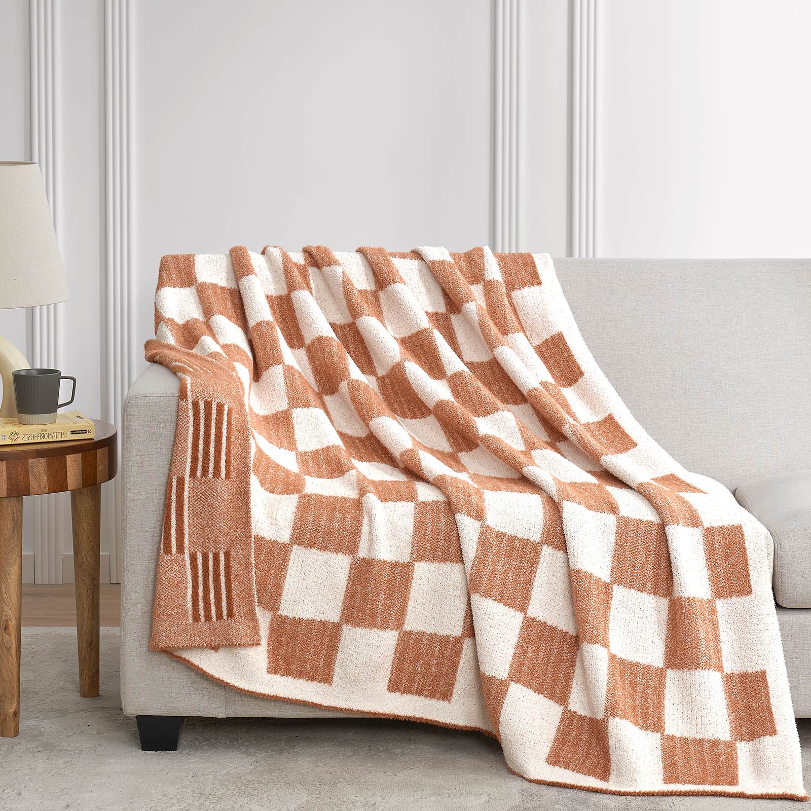 Snuggle Sacs Reversible Heather Checkered Feather Yarn Knit Throw Blanket draped on a grey couch#Color_Heather Orange
