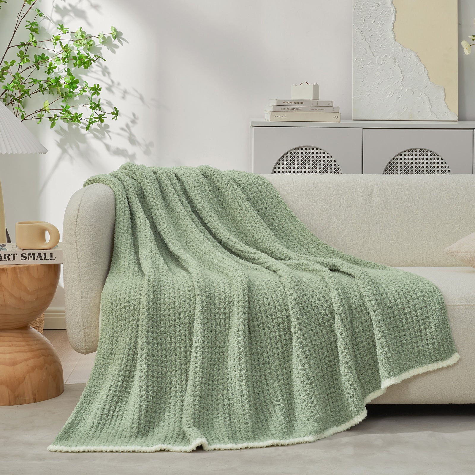 Soft Waffle Feather Yarn Knit Throw Blanket on a beige couch with vase of flower and mug#Color_Sage Green