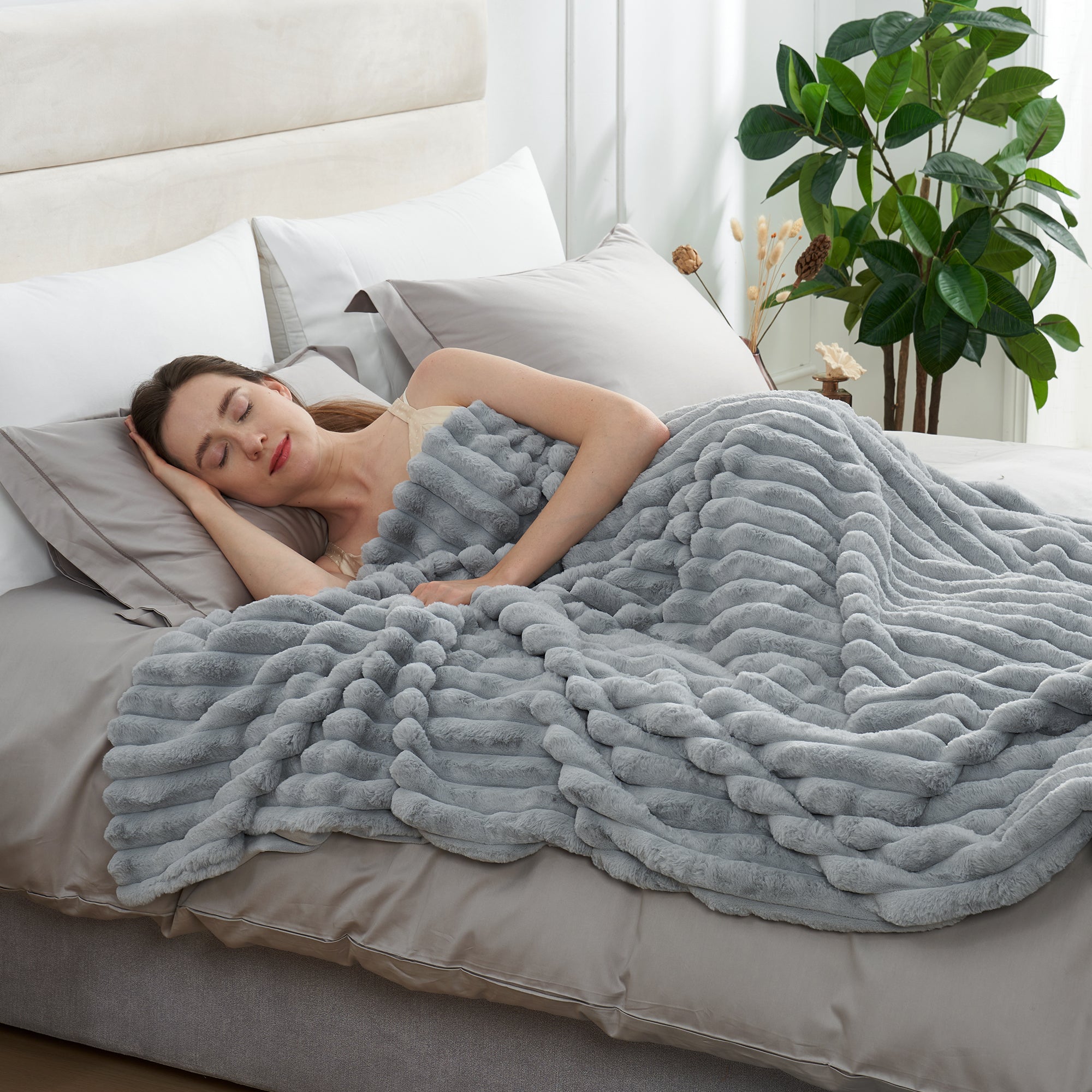 Woman sleeping under a striped faux fur throw blanket in Light Grey for soft and comfortable warmth #color_Light Grey