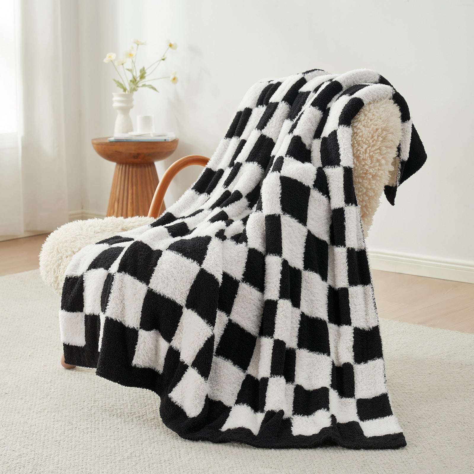 UltraCozy Checkered Feather Yarn Knit Throw Blanket on a beige chair#Color_Black White