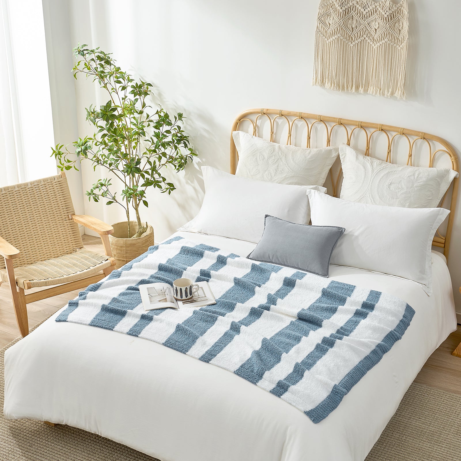 Snuggle Sacs Reversible Blue Striped Feather Yarn Knit Throw Blanket on a bed in a bright room with mug and magazine and plant#color_Blue