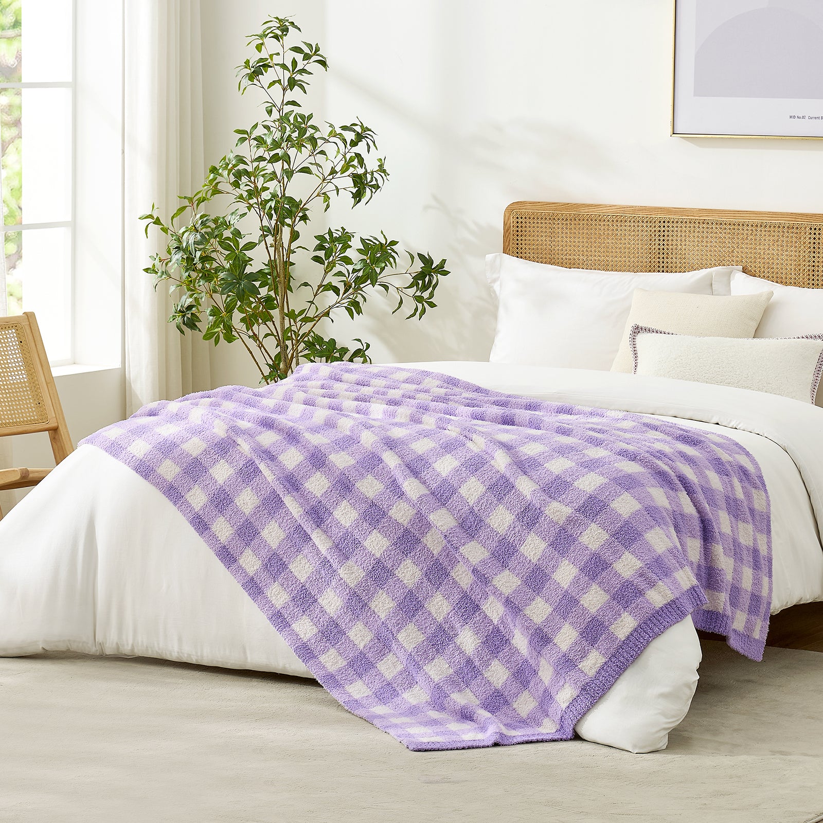 Side view of Purple and white checkered blanket draped over a bed in a bright room with a vase of plants and a window with view #color_Purple