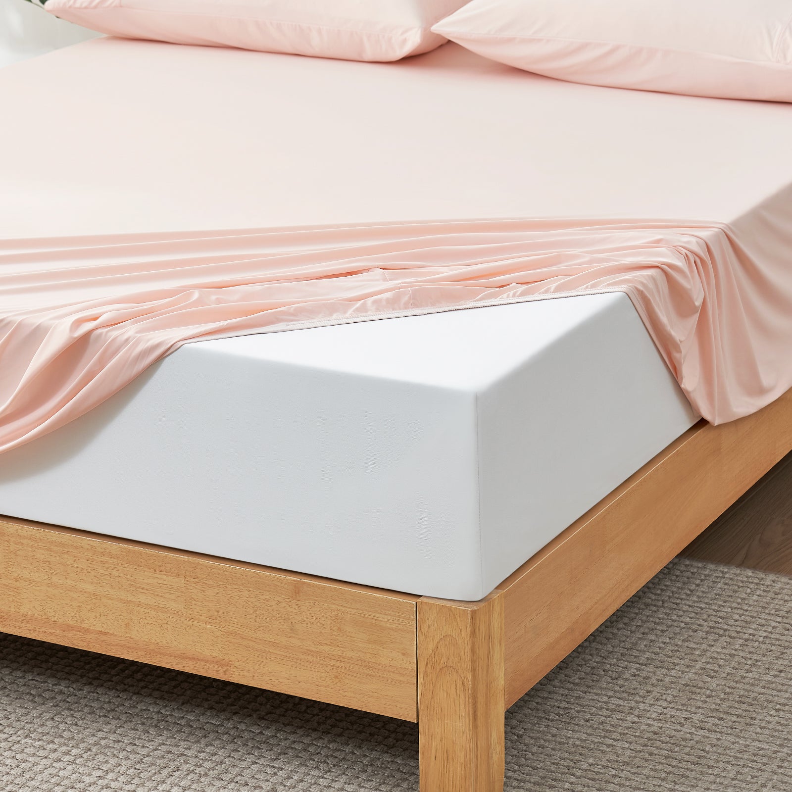 Pink Snuggle Sac fitted sheet set on wooden bed.#color_Pink