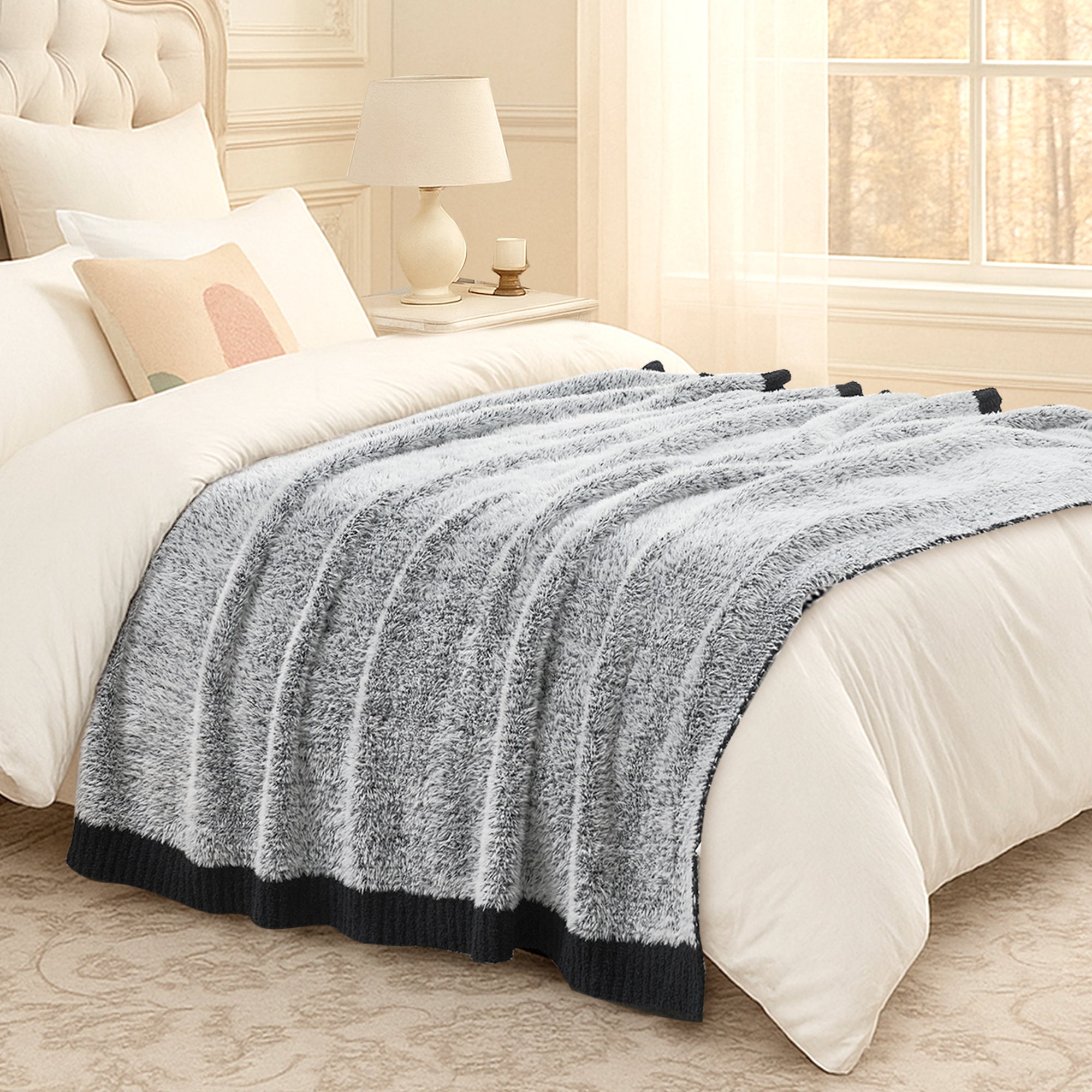 Ultrasoft faux fur knit throw blanket in Black layered on a bed, creating a soft and inviting bedroom look #color_Black