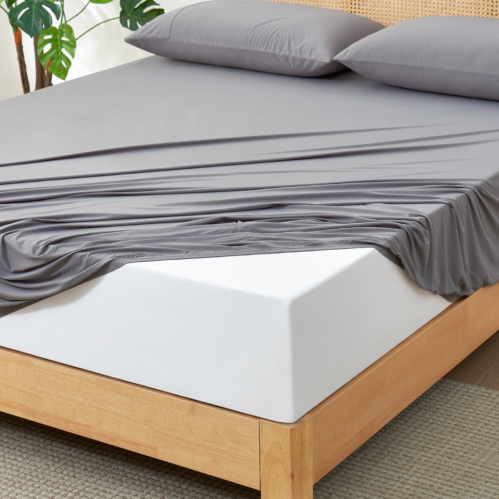 Dark Grey Snuggle Sac fitted sheet set on wooden bed.#color_Dark Grey