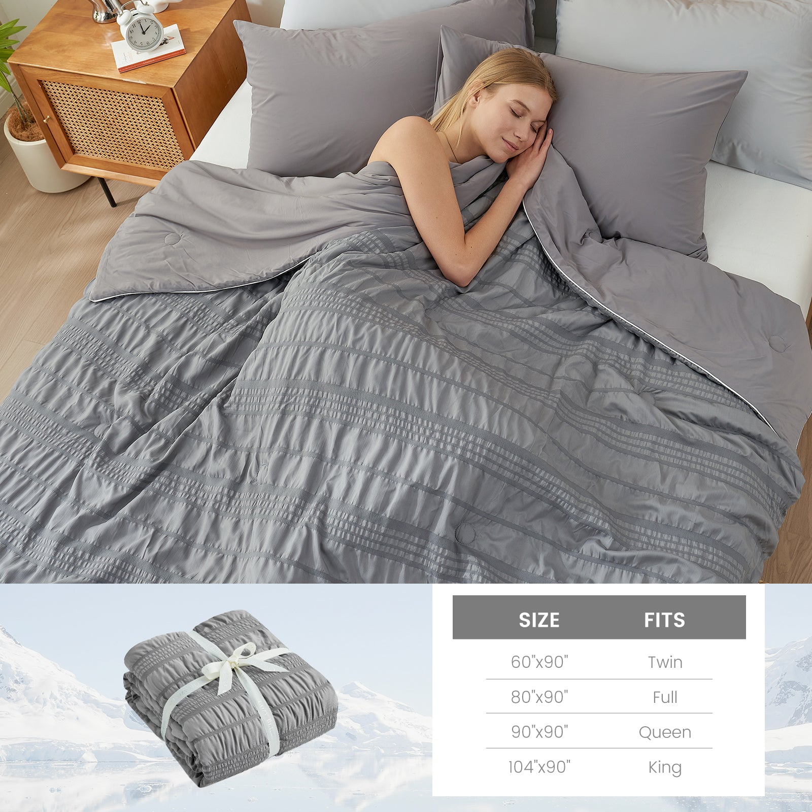 A woman laying down on the bed with Snuggle Sac Cooling comforter #color_Dark Grey
