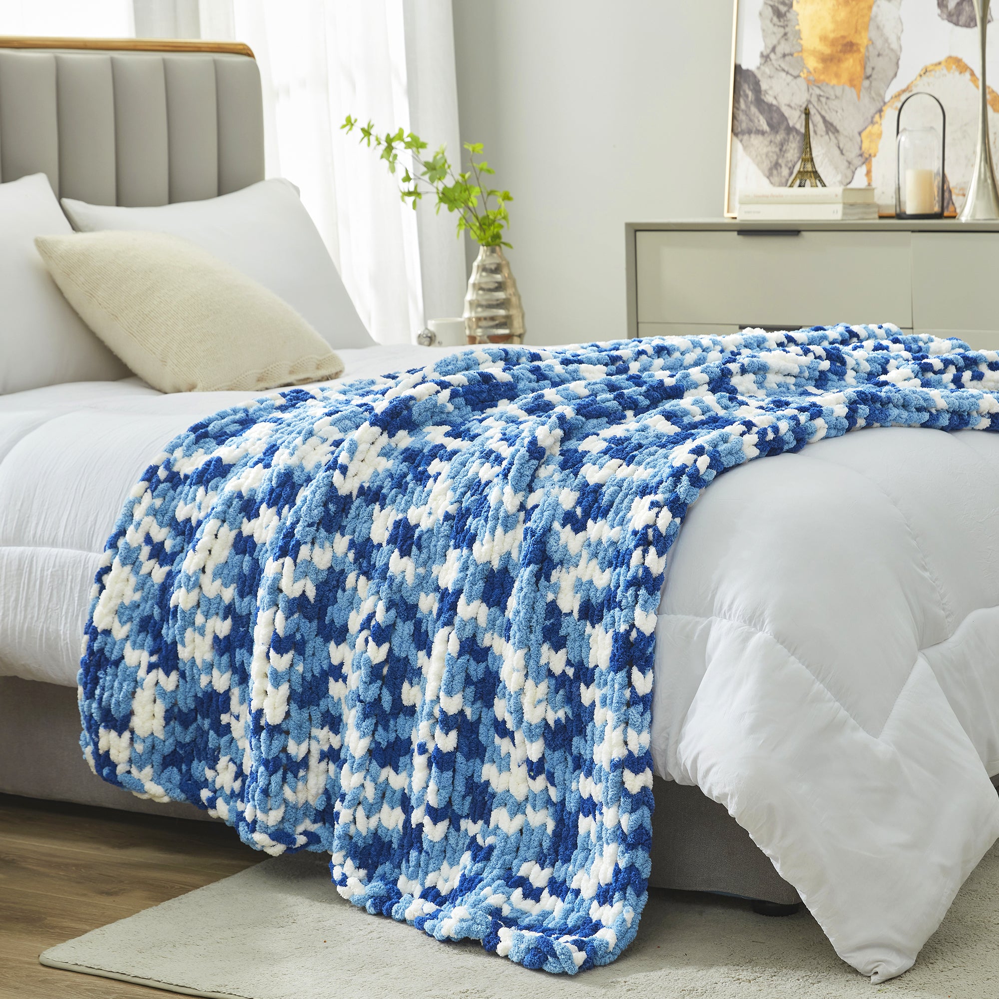 Chunky chenille knit throw blanket in Blue placed at the end of a bed adding texture and warmth #color_Blue