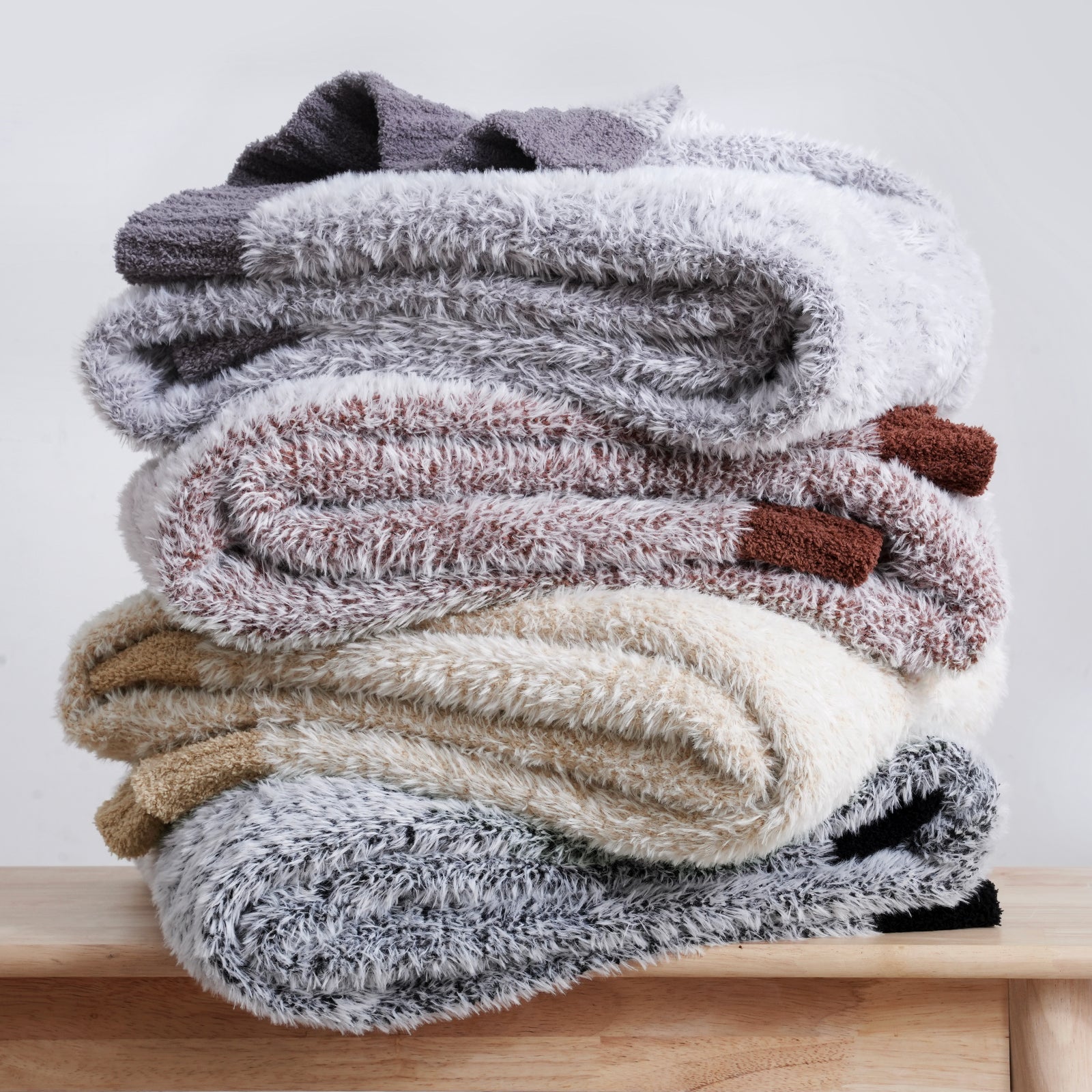 Ultrasoft faux fur knit throw blankets stacked together in multiple colors, highlighting variety and soft texture