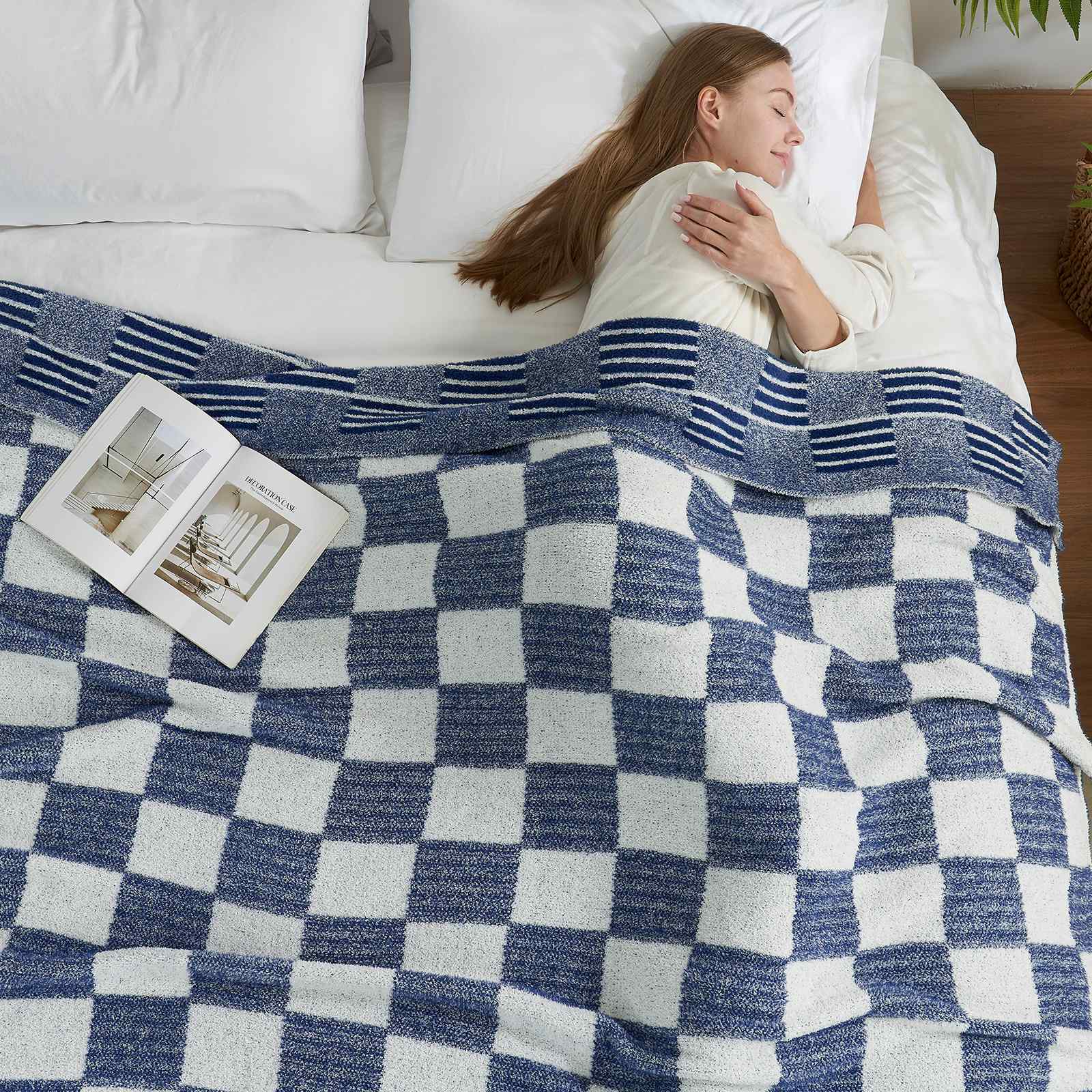 A woman laying on bed with Snuggle Sacs Reversible Heather Checkered Feather Yarn Knit Throw Blanket and a magazine #Color_Heather Navy