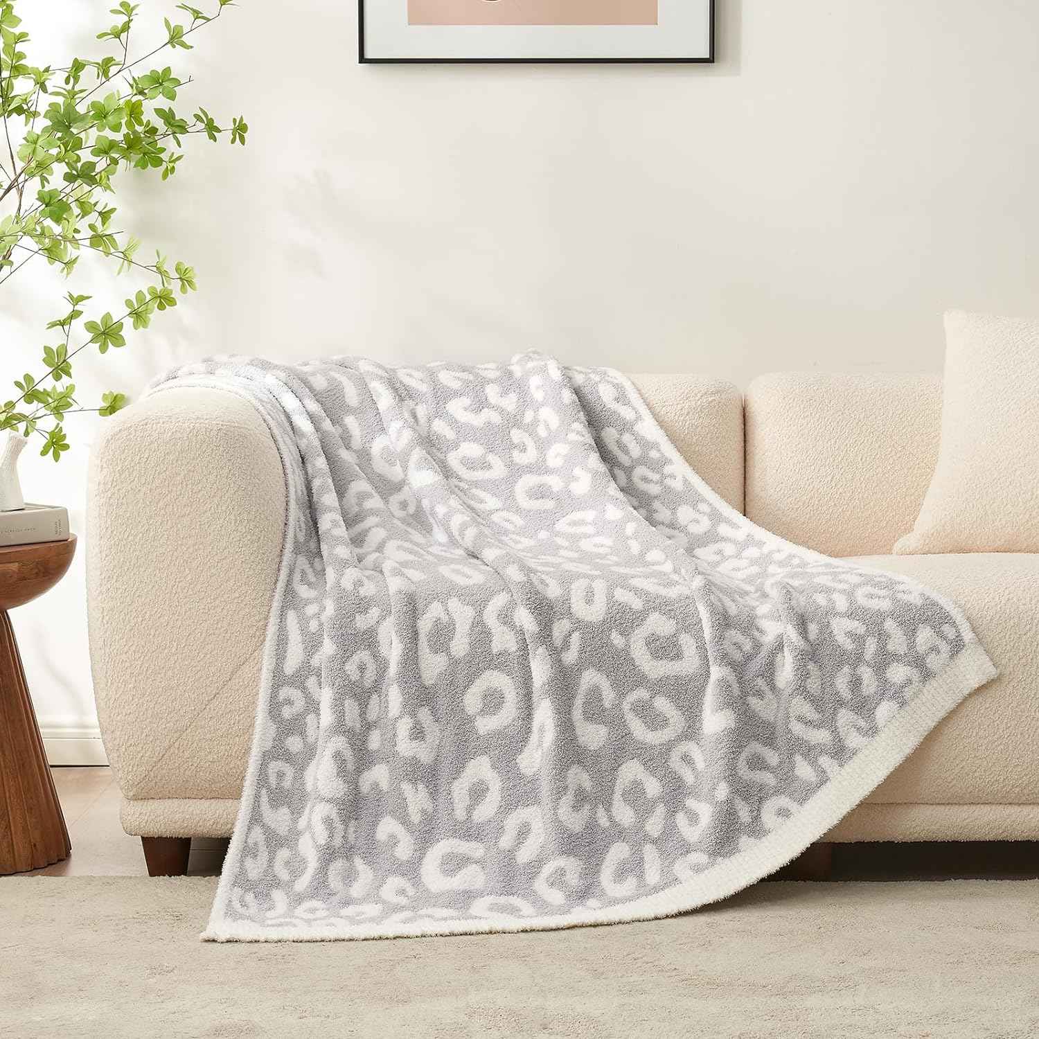 Reversible Leopard Feather Yarn Knit Throw Blanket on a beige couch in a bright room #Color_Leopard Grey