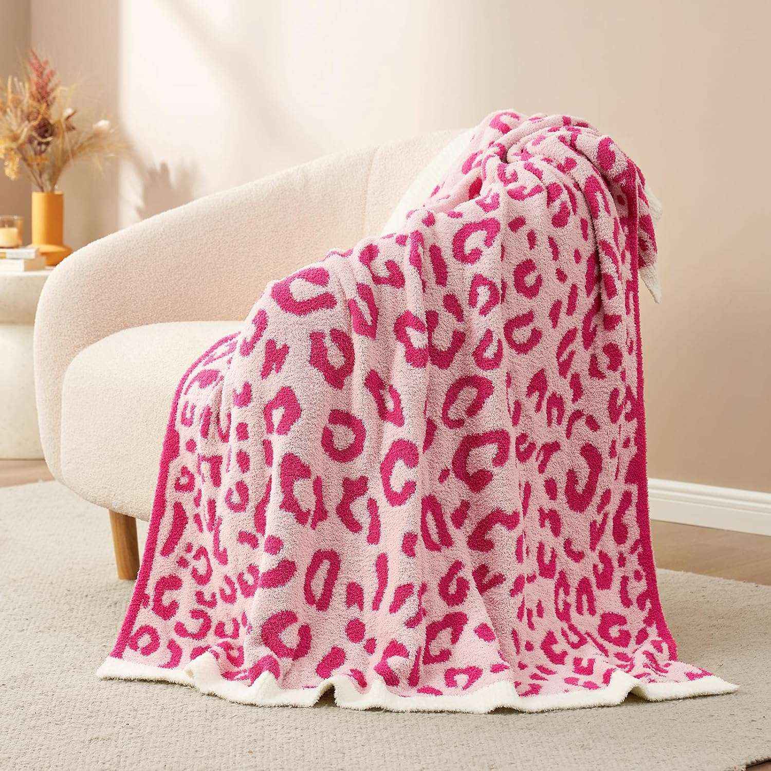 Reversible Leopard Feather Yarn Knit Throw Blanket on a beige couch in a bright room #Color_Hot Pink