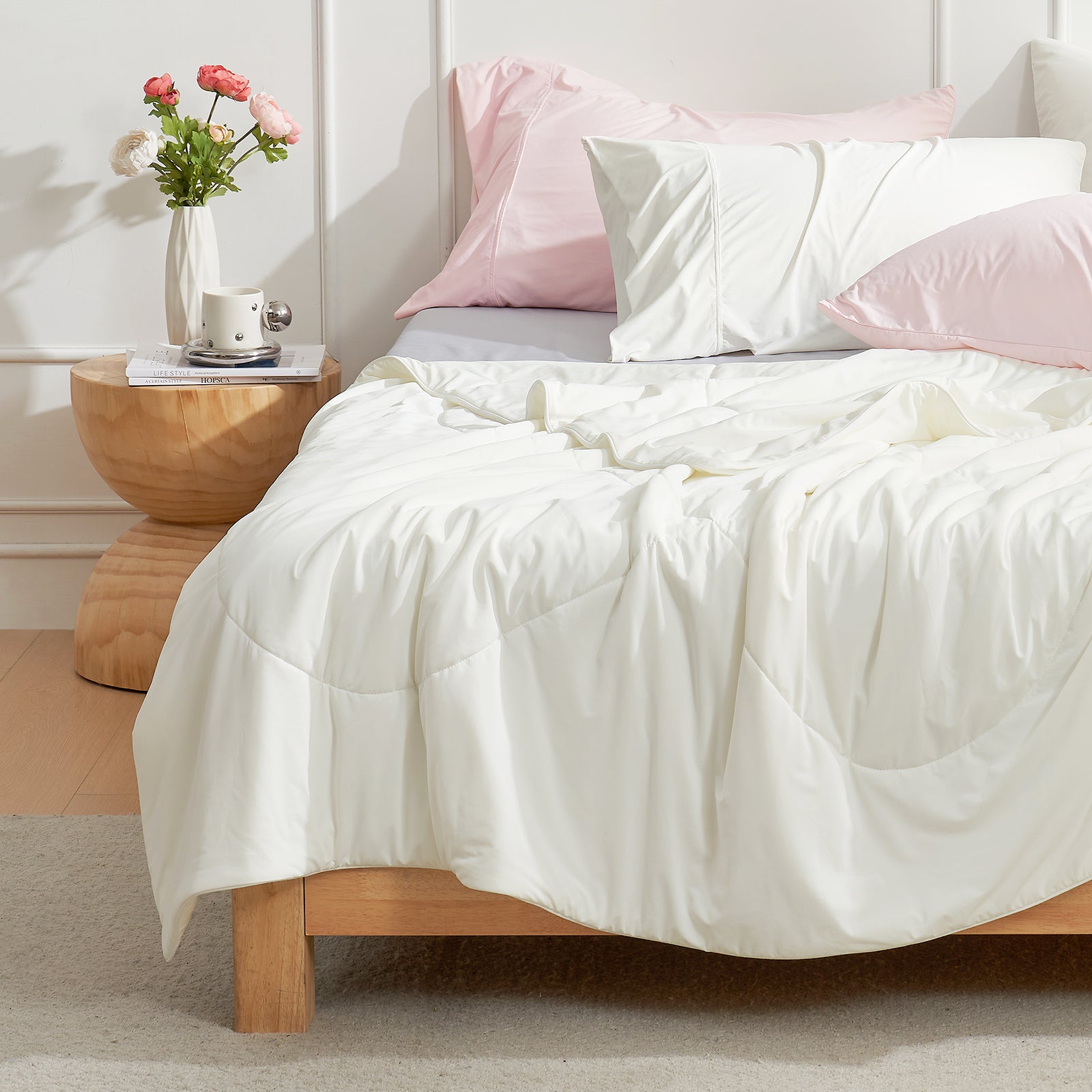 Bed with Snuggle Sac cream white cooling comforter and pillows in a bedroom setting.#color_Cream White