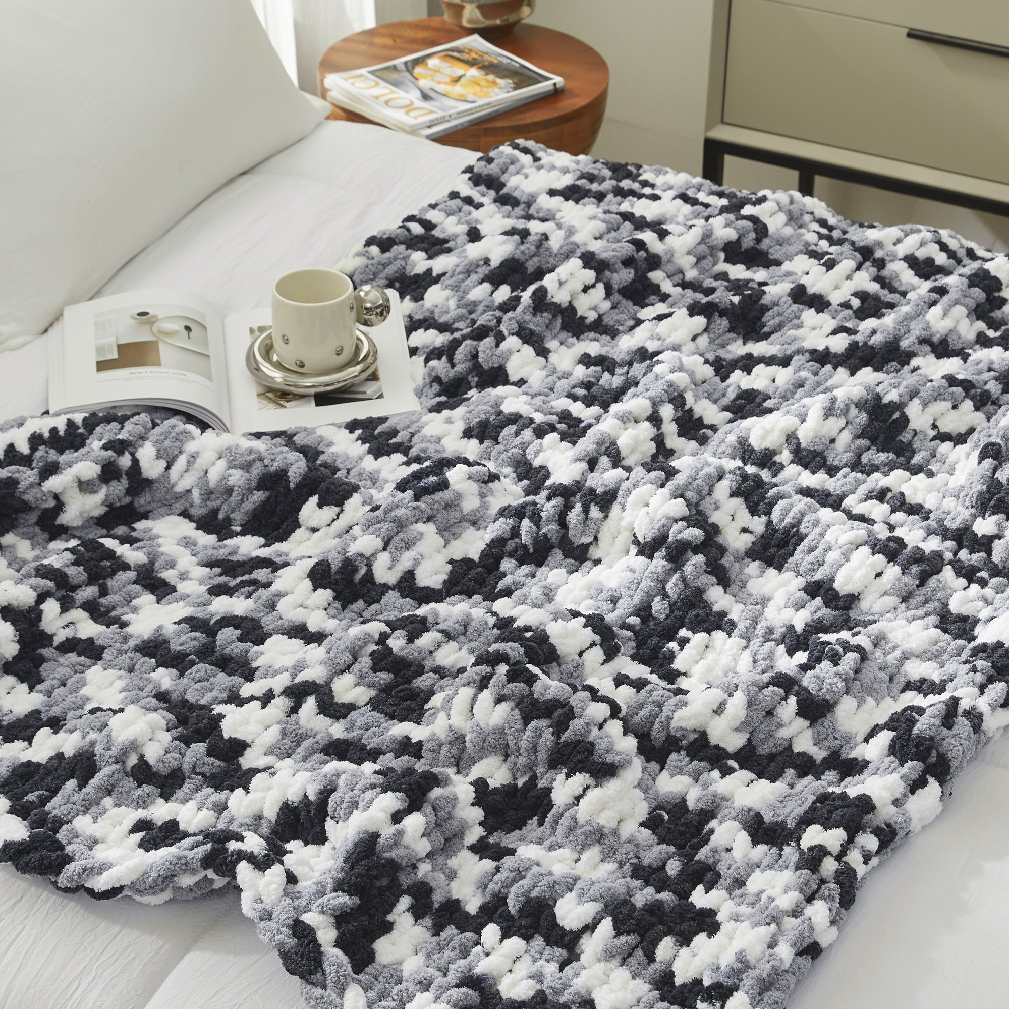 Close up of chunky chenille knit throw blanket in Black laid flat showcasing plush texture #color_Black
