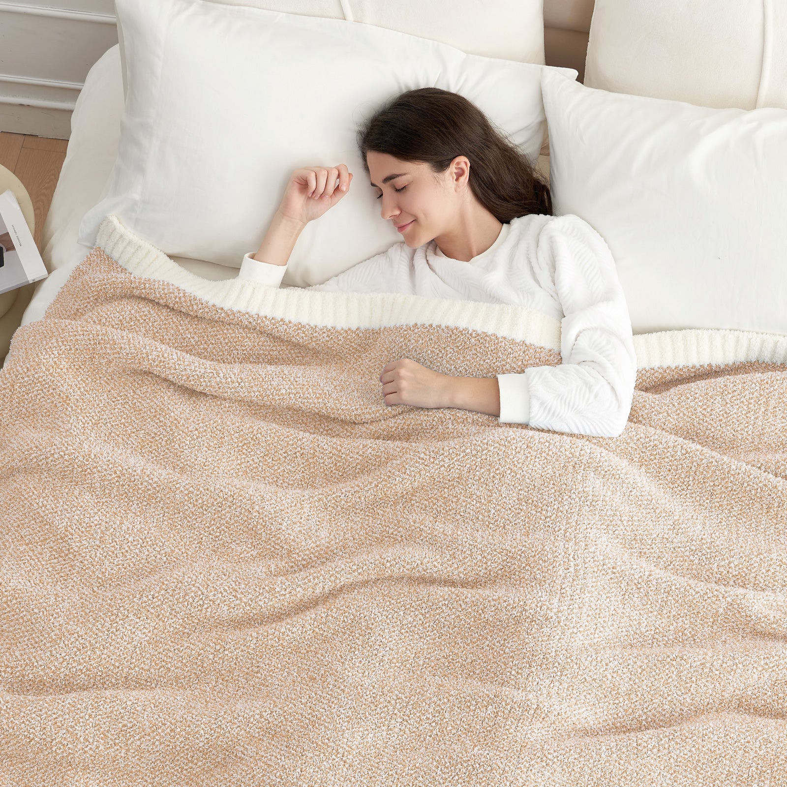 A woman sleeping under Snuggle Sac Heather Feather Yarn Knit Throw Blanket#color_Cream/Beige