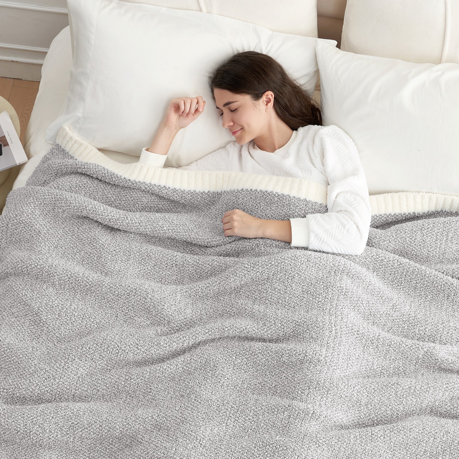 A woman sleeping under Snuggle Sac Heather Feather Yarn Knit Throw Blanket#Color_Grey