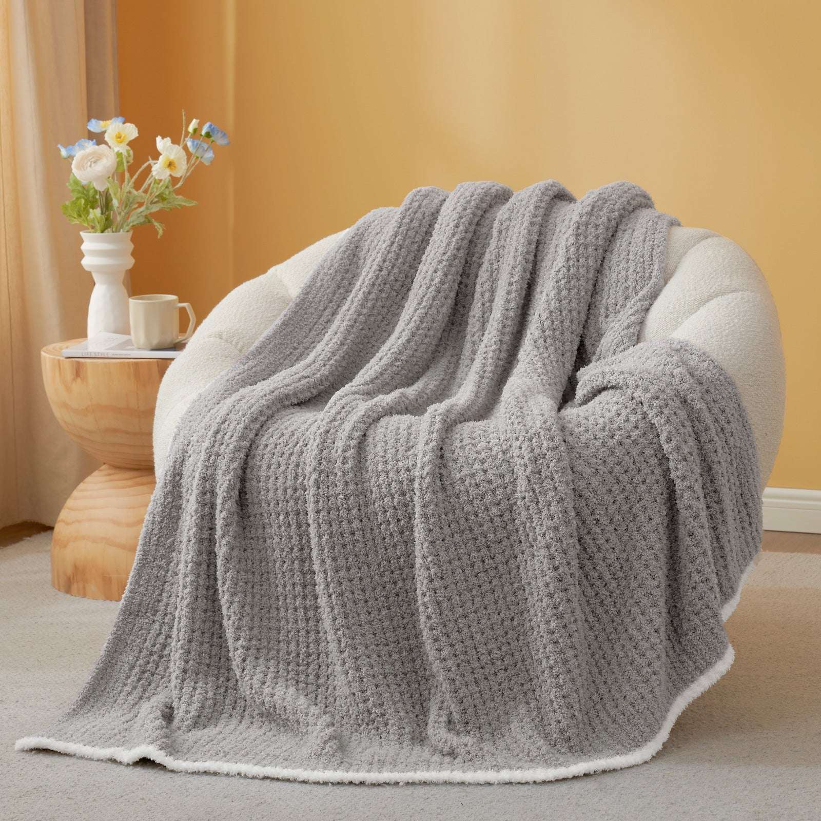  Soft Waffle Feather Yarn Knit Throw Blanket on a beige chair with vase of flower and mug#Color_Grey