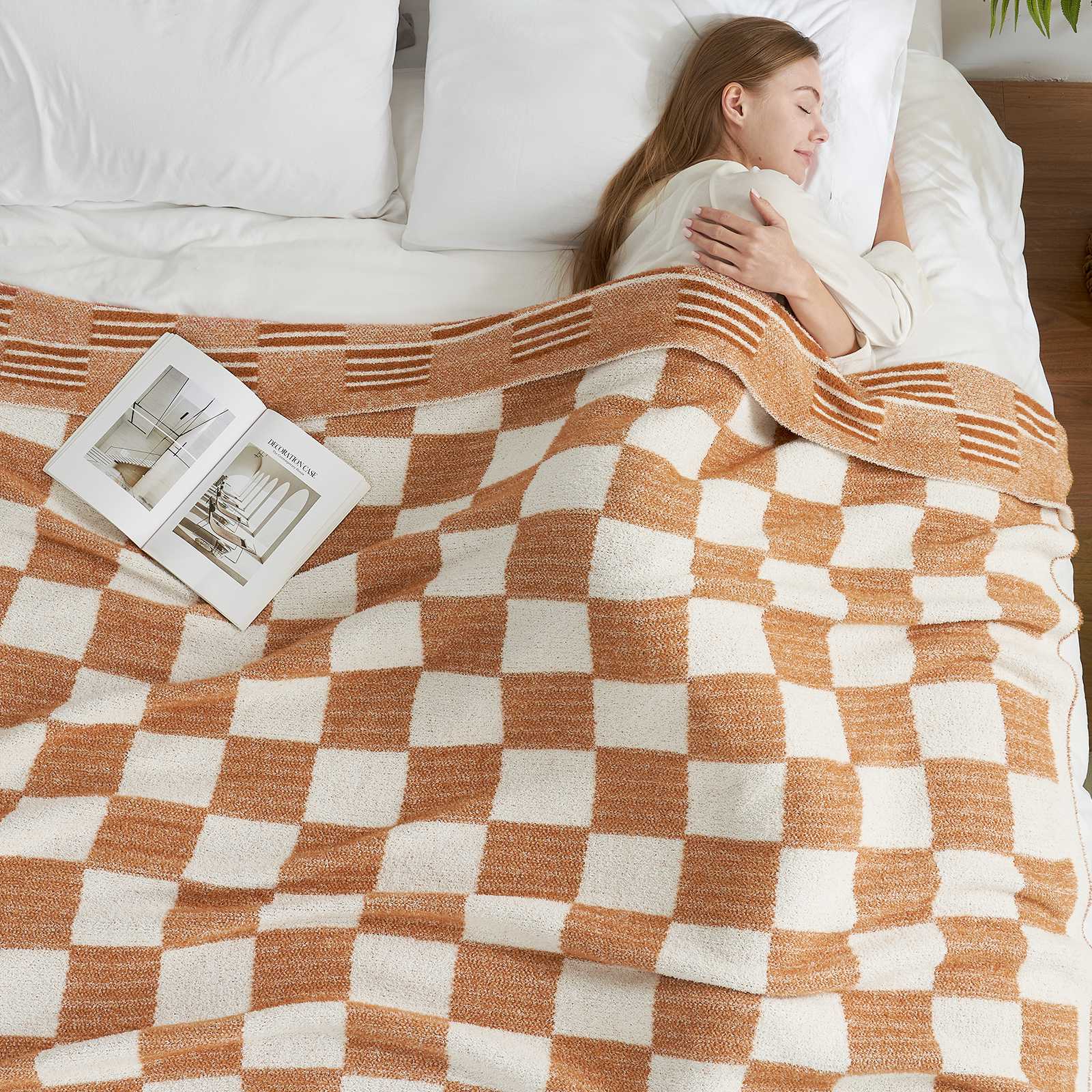 A woman laying on bed with Snuggle Sacs Reversible Heather Checkered Feather Yarn Knit Throw Blanket and a magazine #Color_Heather Orange