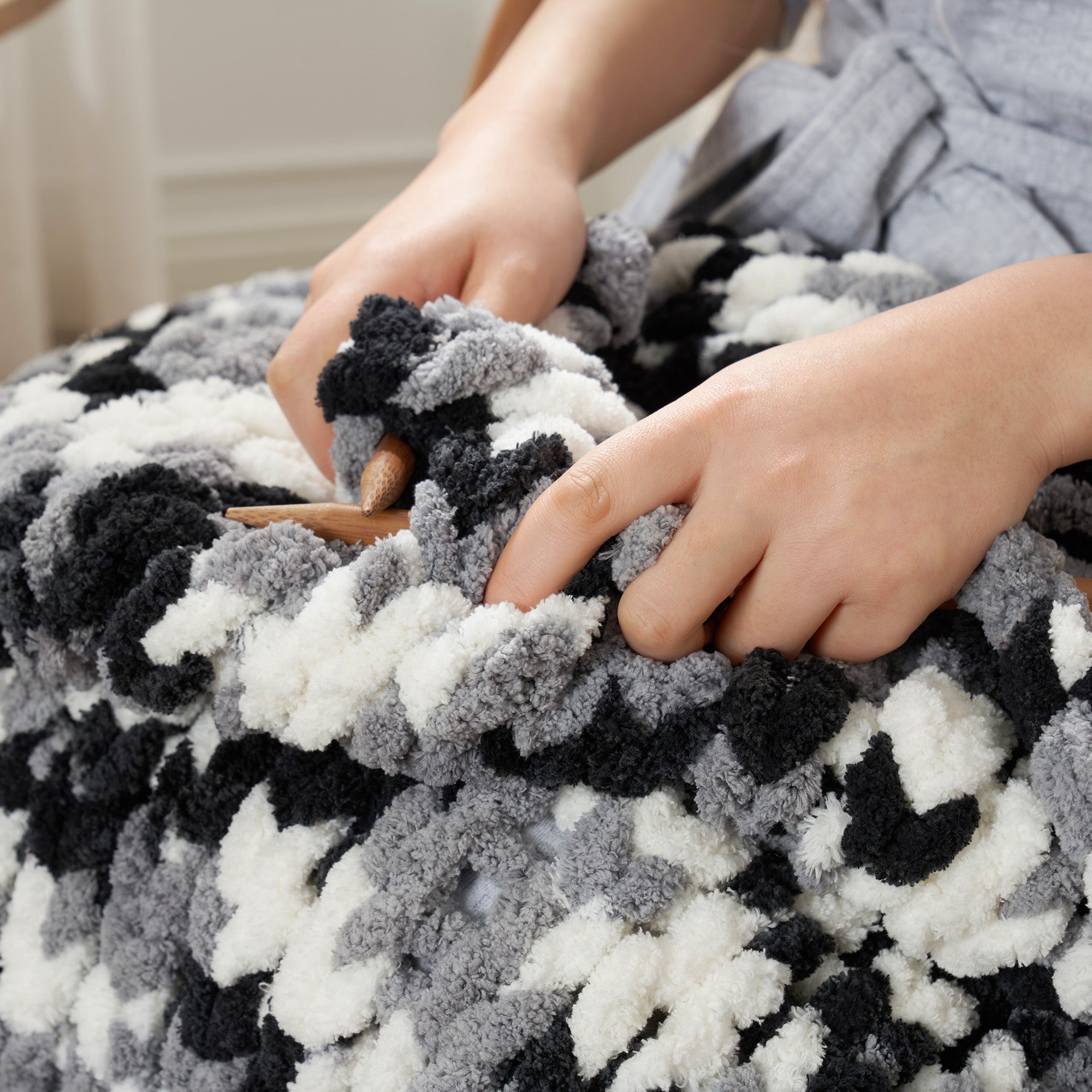 Close up of handmade chunky chenille yarn in Black being knitted showing thick soft loops #color_Black