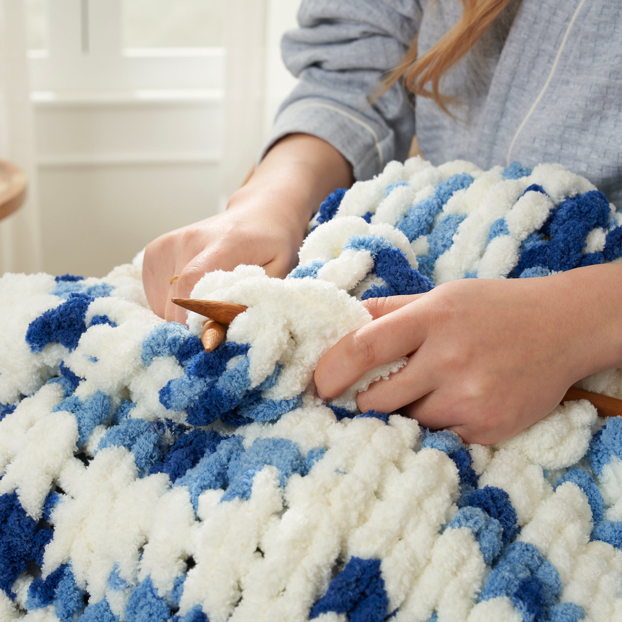Close up of handmade chunky chenille yarn in Blue Stripe being knitted showing thick soft loops #color_Blue Stripe