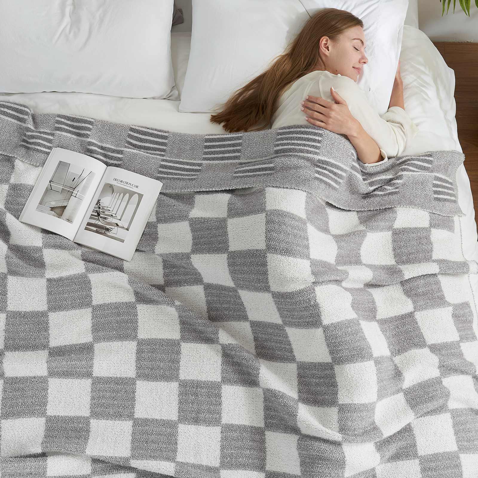 A woman laying on bed with Snuggle Sacs Reversible Heather Checkered Feather Yarn Knit Throw Blanket and a magazine #Color_Heather Grey