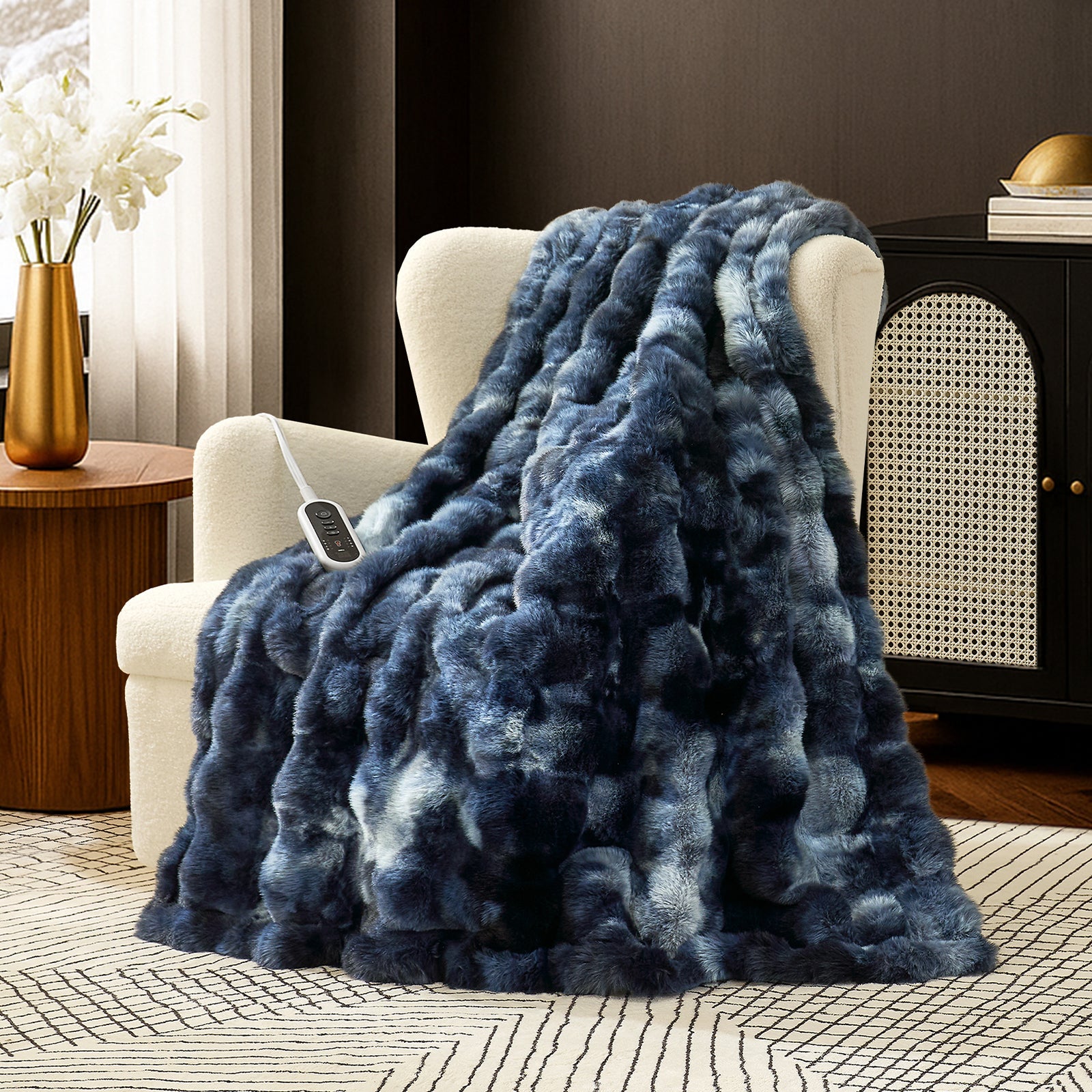 Snuggle Sac bubble faux fur electric blanket in Tie-dye Blue draped over a chair with controller, creating a warm and cozy setting #color_Tie-dye Blue