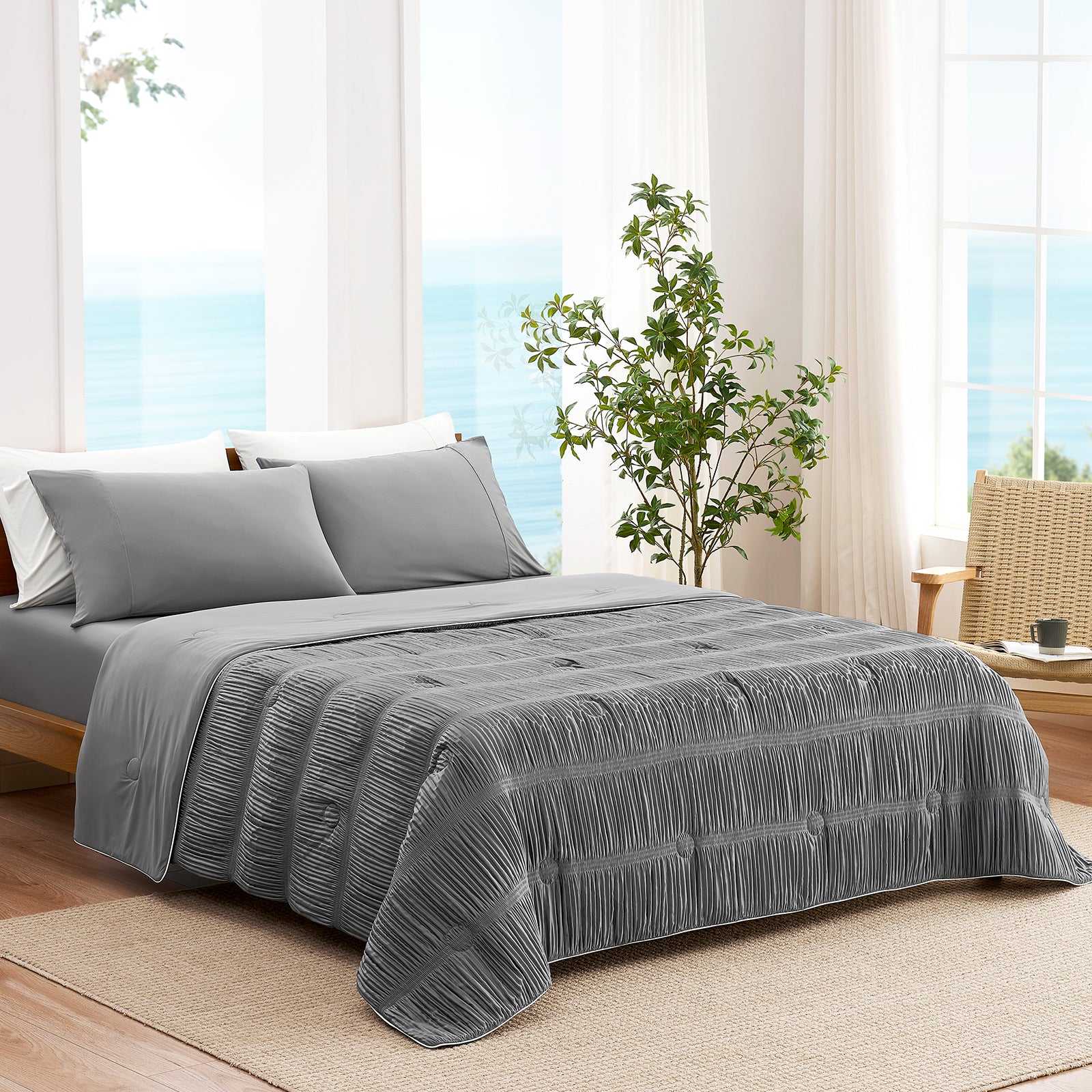 Snuggle Sac Cooling comforter in dark grey on bed in a bedroom with windows,plant and a view behind
#color_Dark Grey