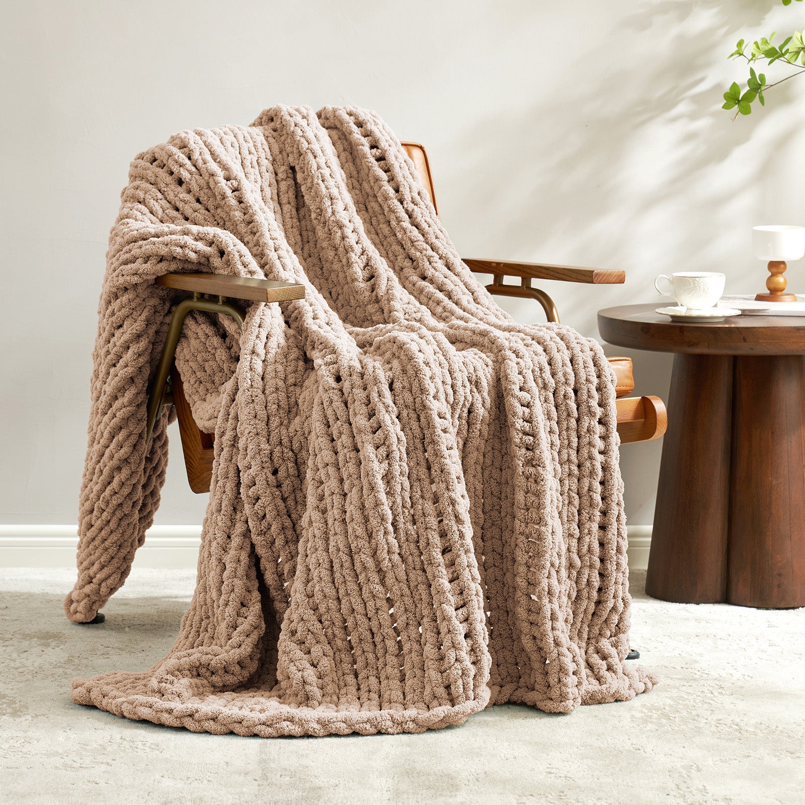 Snuggle Sac chunky knit throw blanket in Beige draped over a chair in a cozy living space #color_Beige