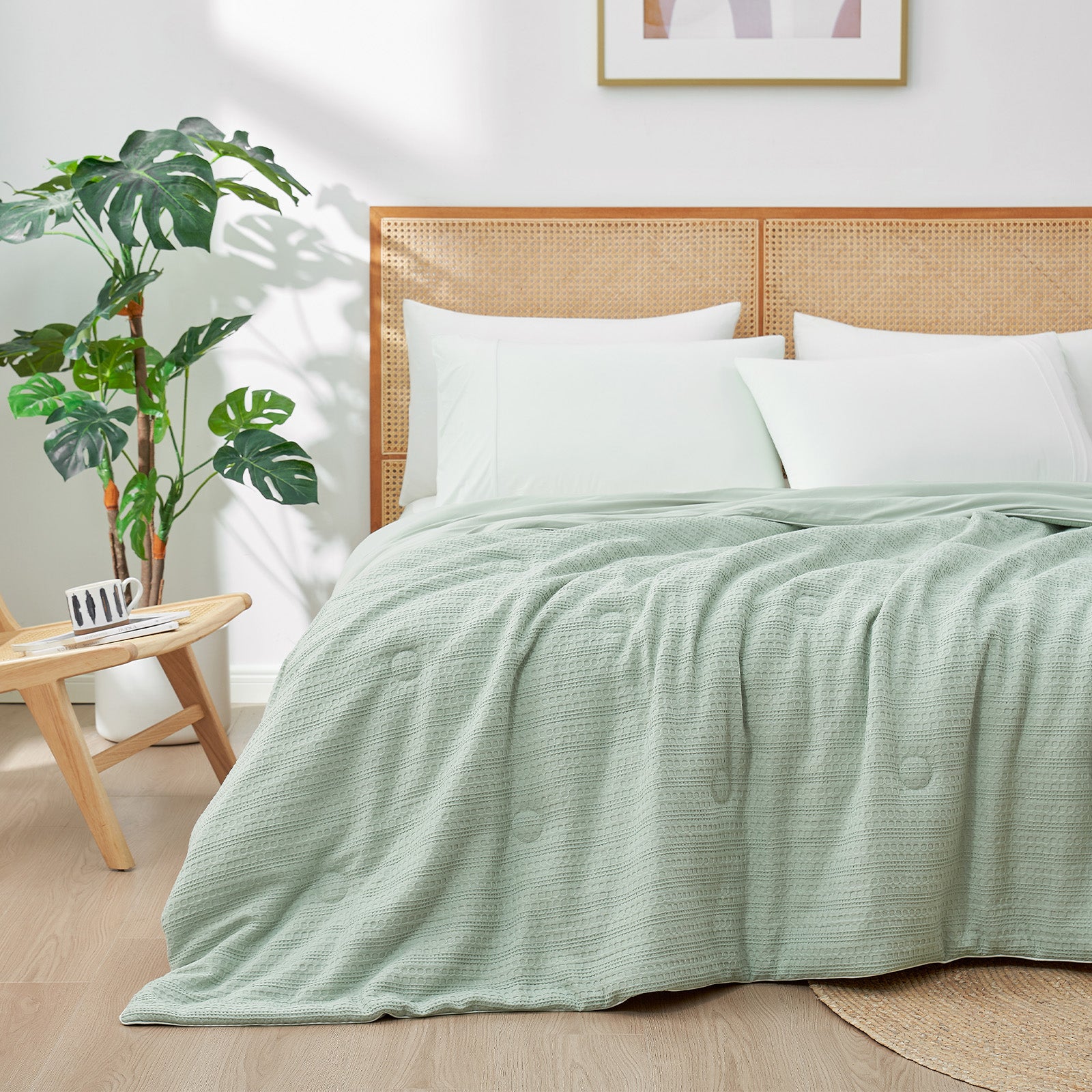 Snuggle Sac Cooling comforter in sage green on bed in a bedroom with plants#color_Sage Green