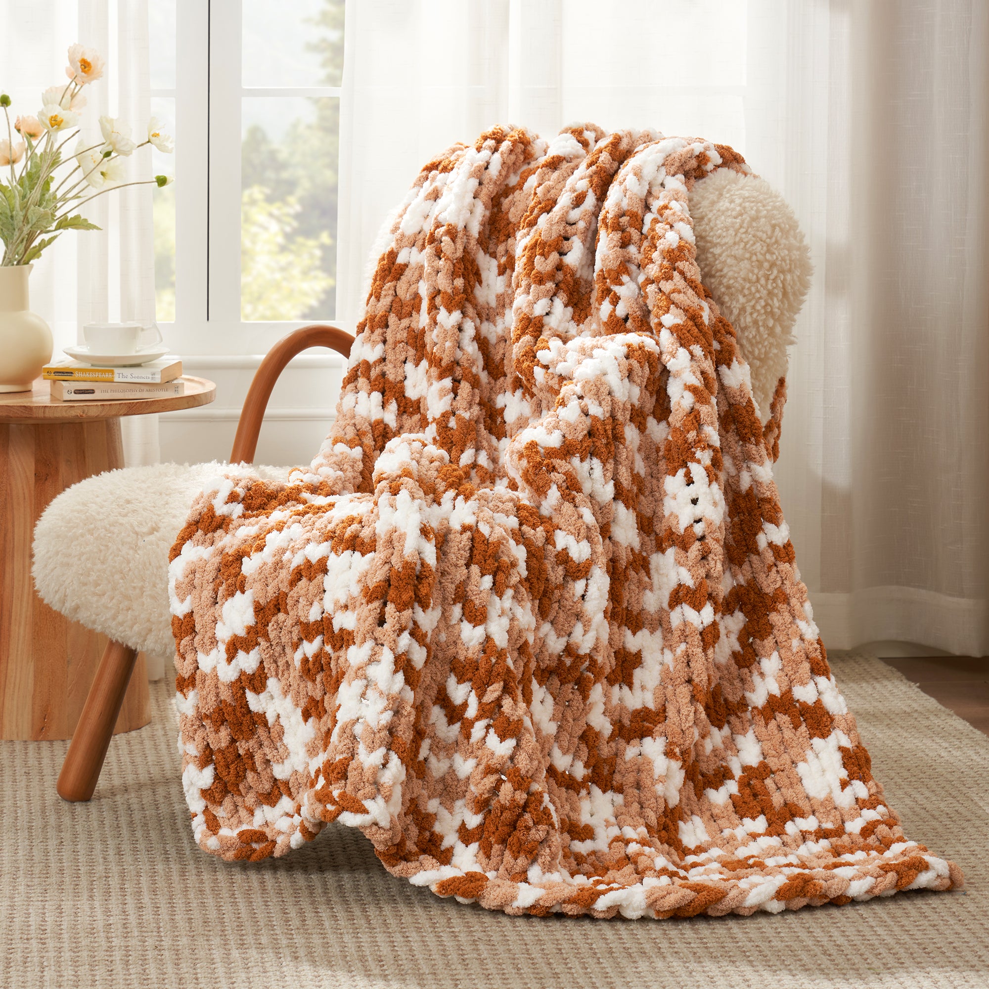 Snuggle Sac chunky chenille knit throw blanket in Burnt Orange draped over a chair creating a cozy corner #color_Burnt Orange