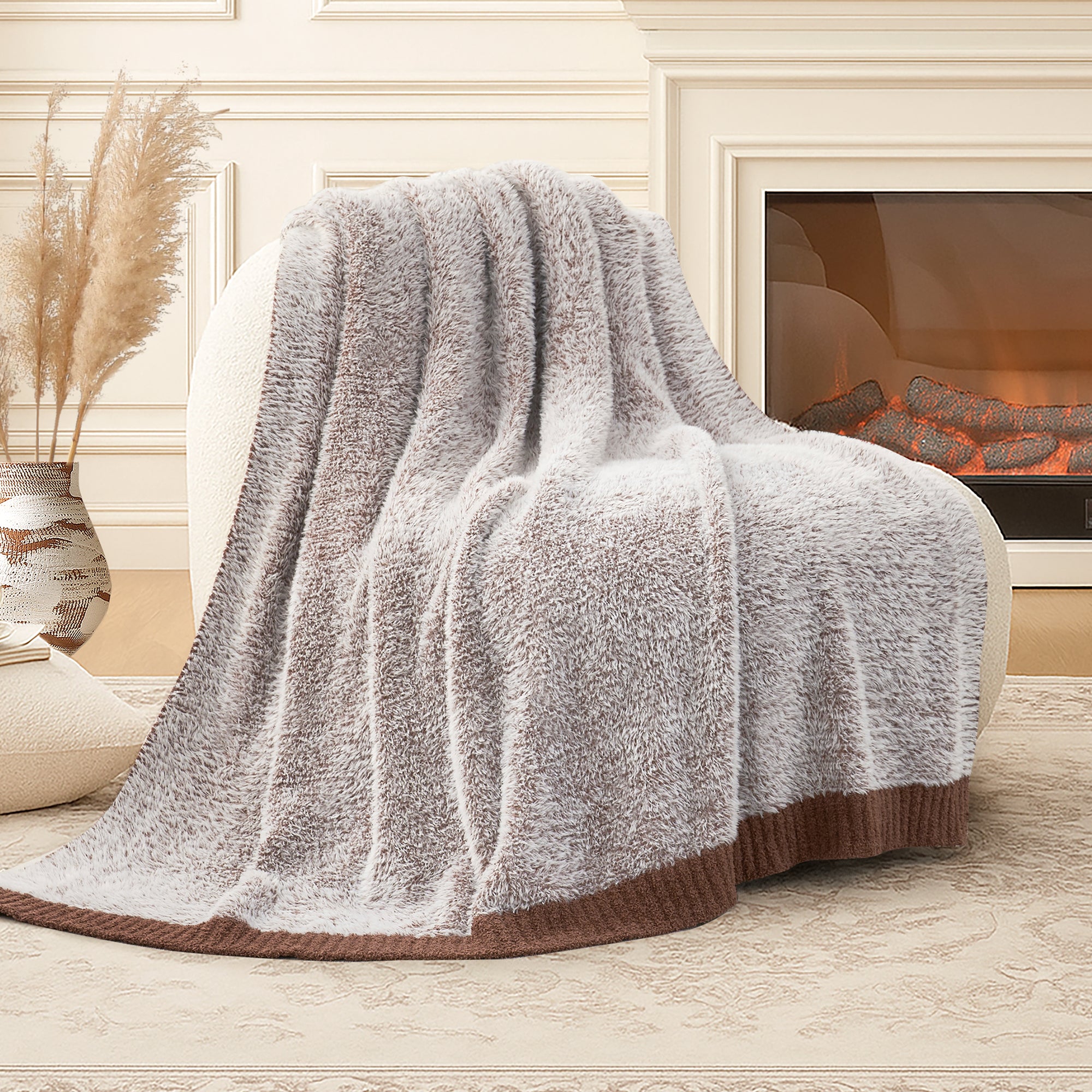 Snuggle Sac ultrasoft faux fur knit throw blanket in Brown draped over a sofa near a fireplace, creating a warm and cozy atmosphere #color_Brown