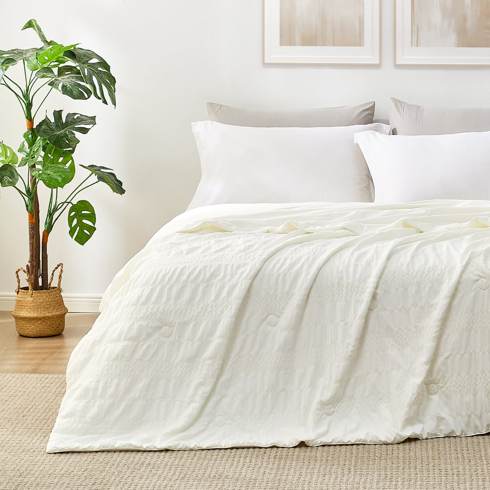 Snuggle Sac Cooling comforter in white on bed in a bedroom with plants
#color_White