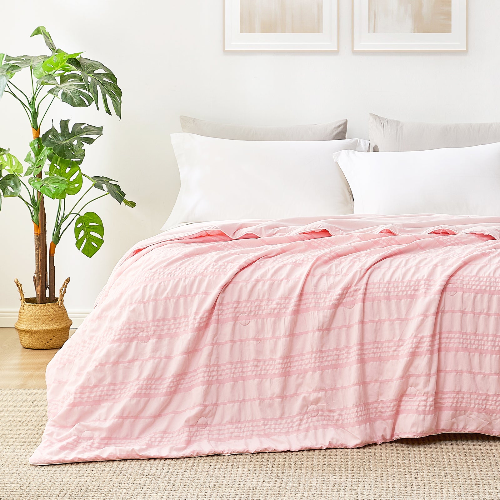Snuggle Sac Cooling comforter in pink on bed in a bedroom with plants#color_Pink