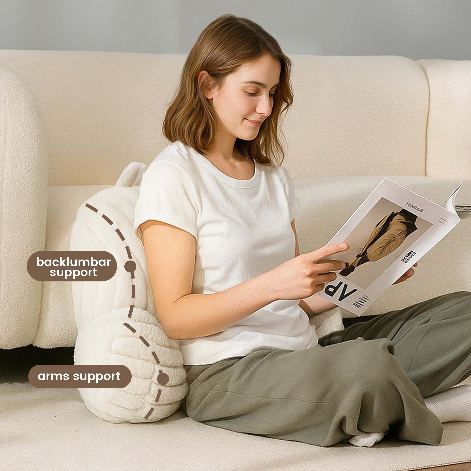 A woman sitting on the floow supported by Striped Faux Fur Backrest Reading Pillow reading a magazine#color_Ivory