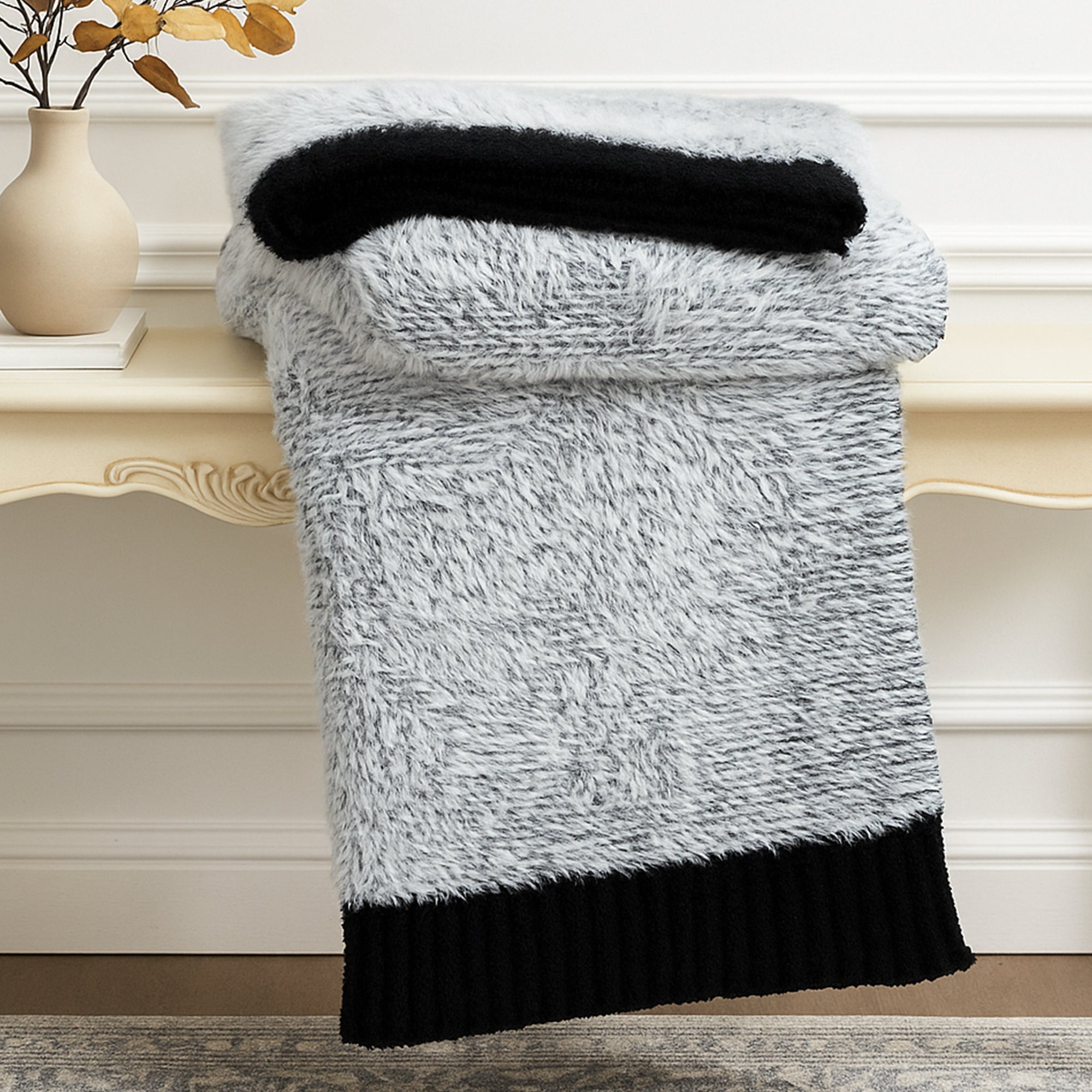 Ultrasoft faux fur knit throw blanket in Black neatly folded on a wooden table, showcasing thick and plush texture #color_Black