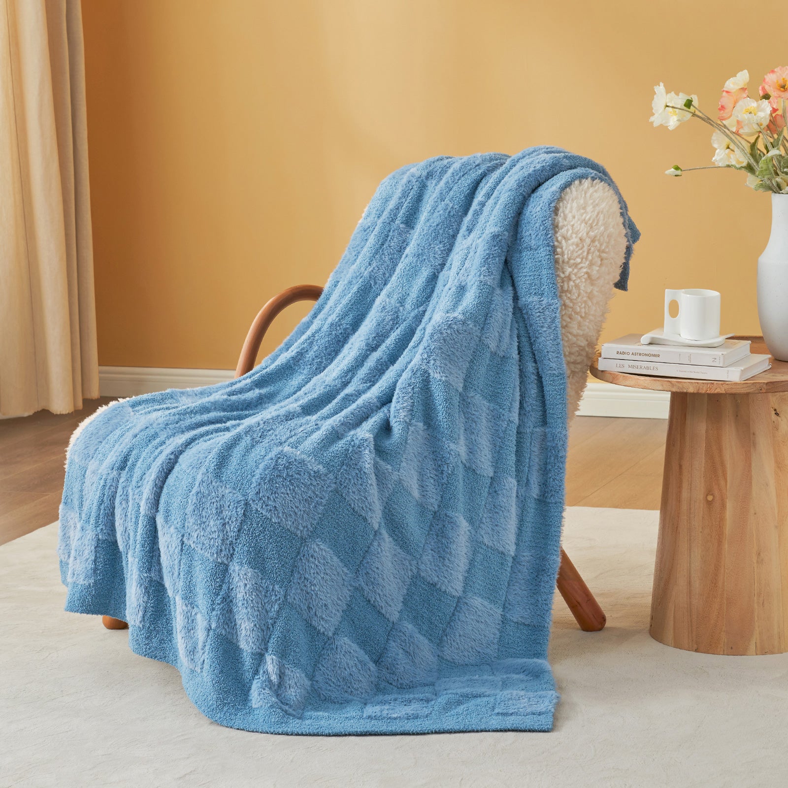 UltraCozy Solid Checkered Feather Yarn Knit Throw Blanket on a beige chair with candle and magazine - #Color_Solid Blue