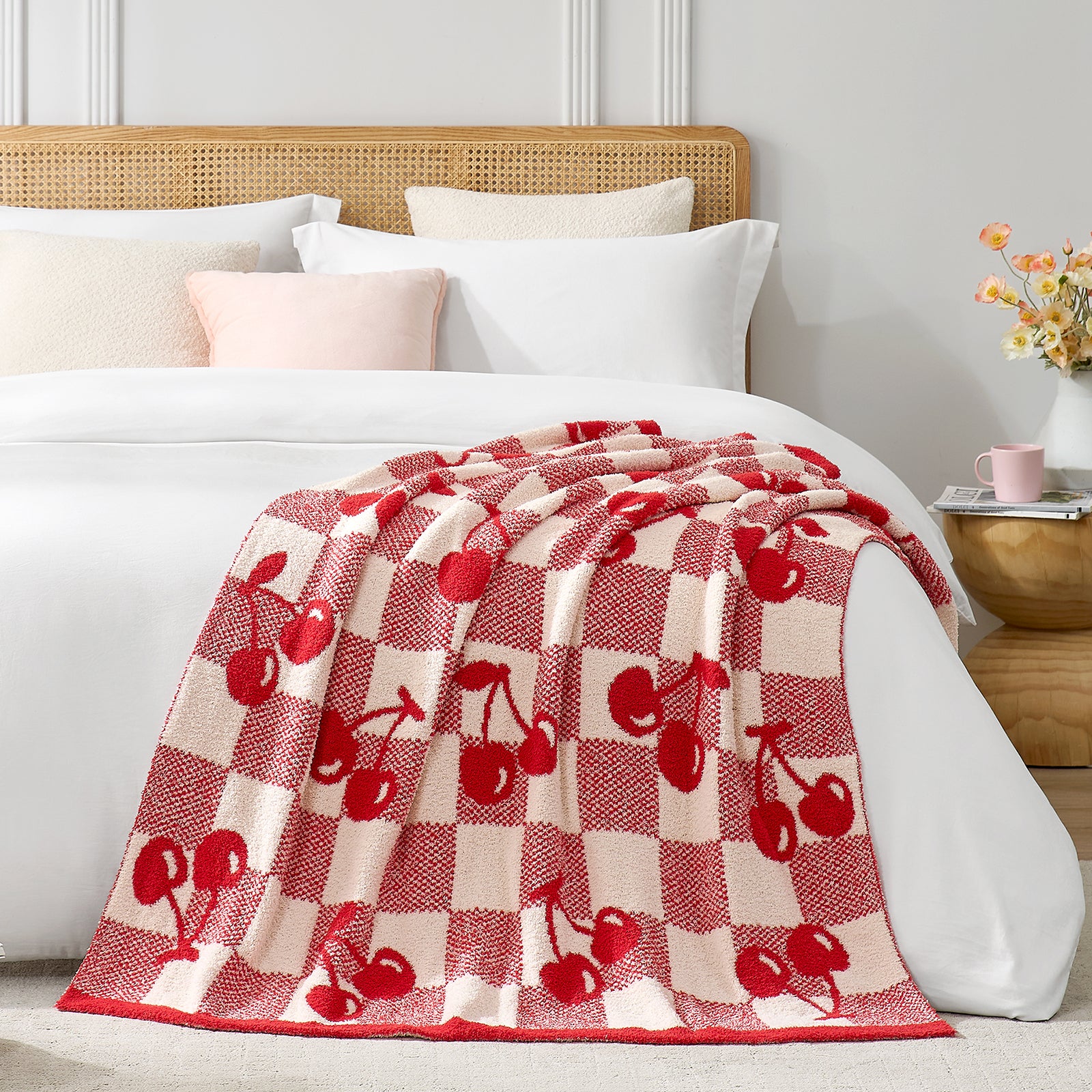 Snuggle Sacs Red Cherry Feather Yarn Knit Throw Blanket on the bed with a vase of flower and a mug in the room#color_Red_Cherry