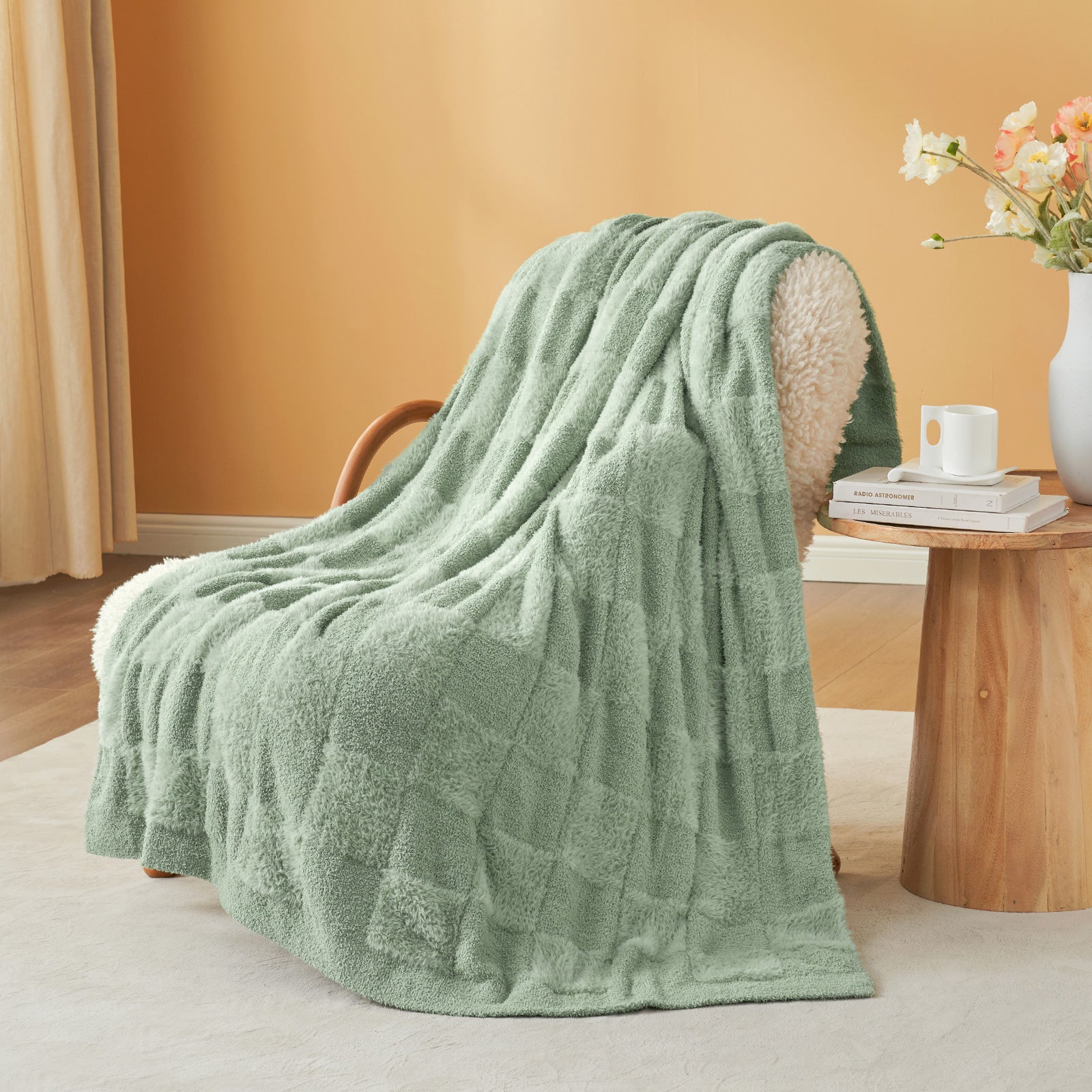 UltraCozy Solid Checkered Feather Yarn Knit Throw Blanket on a beige chair with candle and magazine - #Color_Sage Green