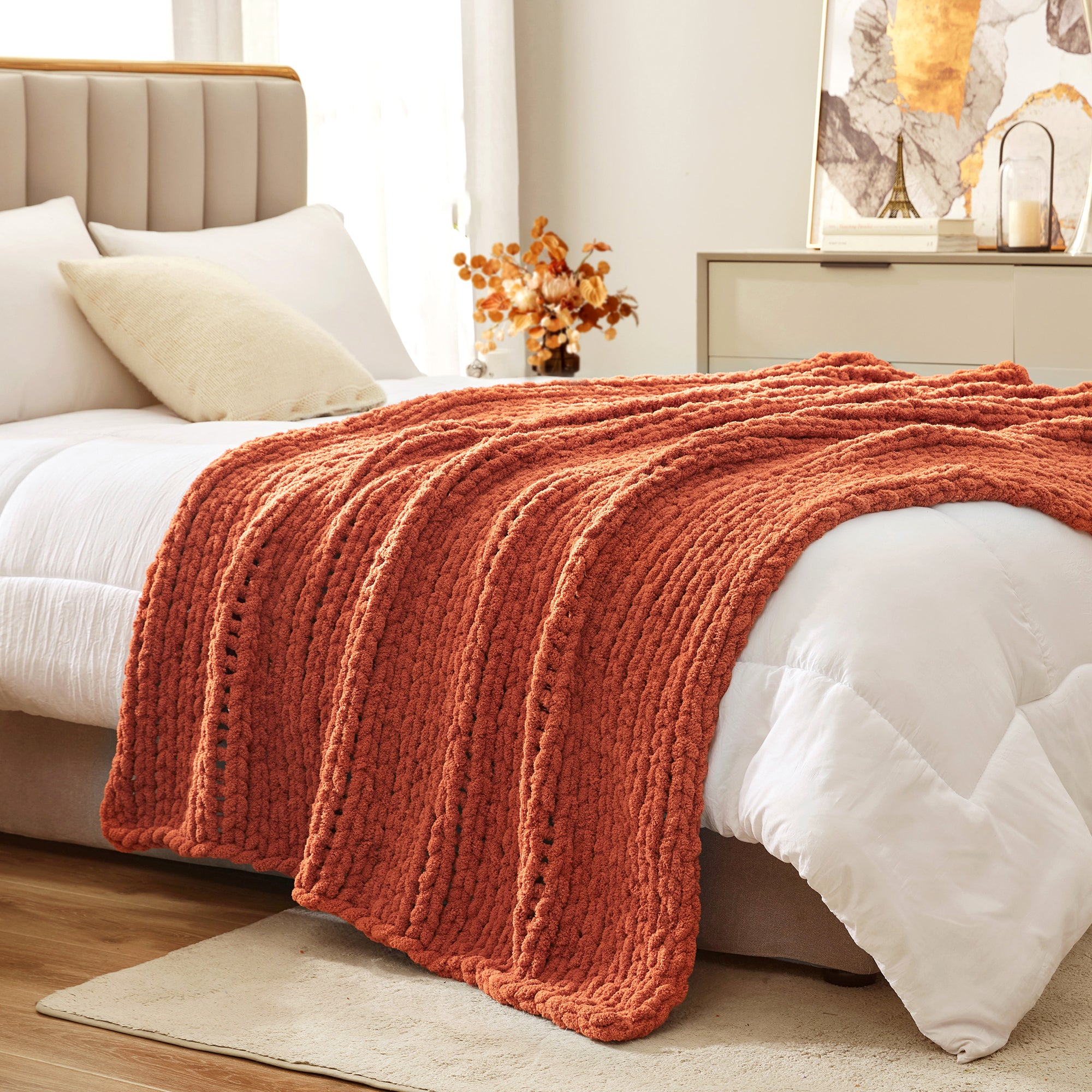 Soft chunky knit throw blanket in Burnt Orange layered on bed in a modern bedroom setting #color_Burnt Orange