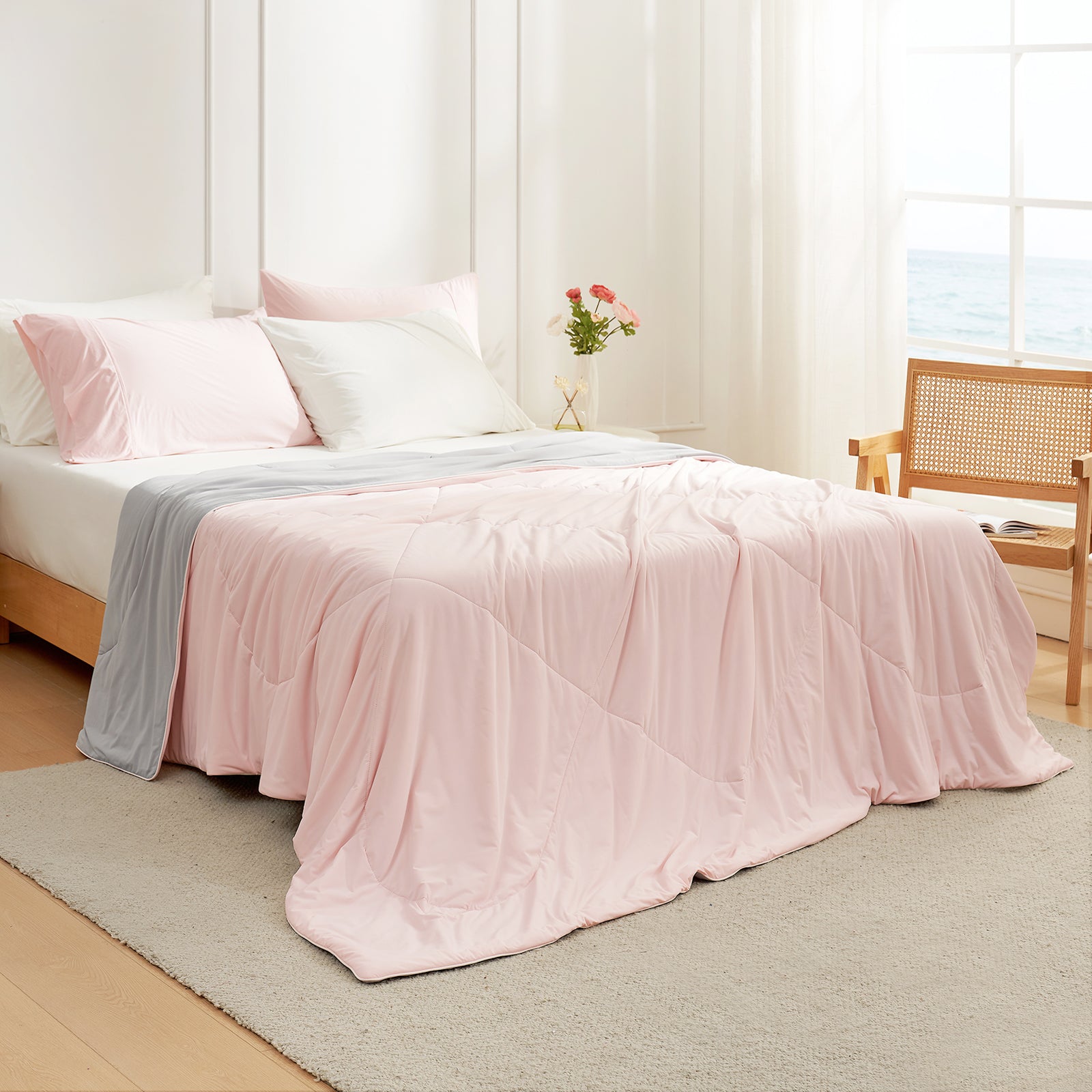 Bedroom view at 45 degrees, featuring a pink/grey Snuggle Sac cooling comforter on the bed for hot sleepers#color_Pink/Grey