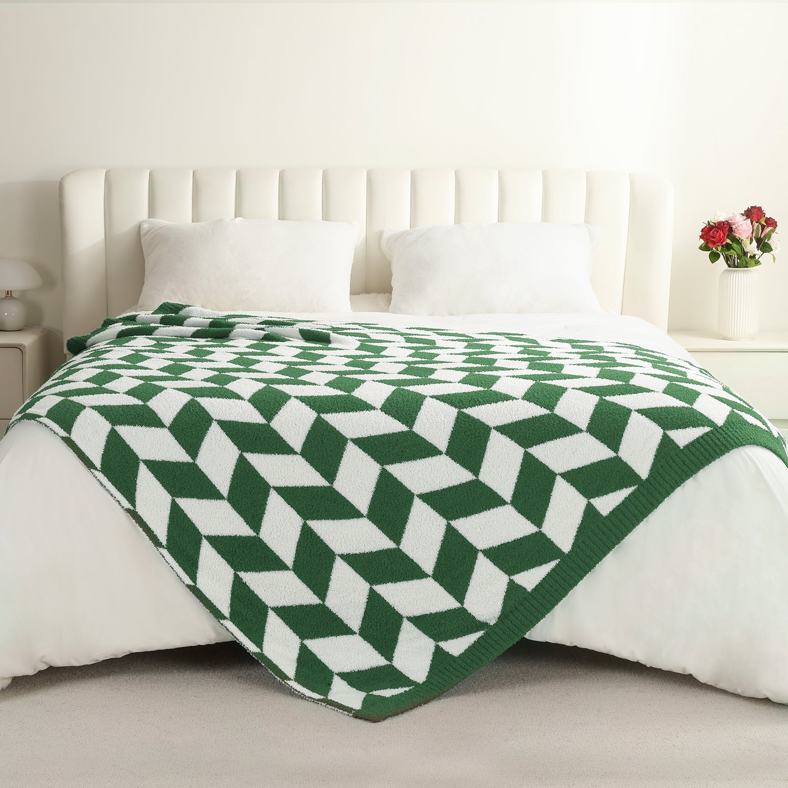 Green and white geometric patterned blanket on a bed with a white  headboard. #color_ Xmas Green