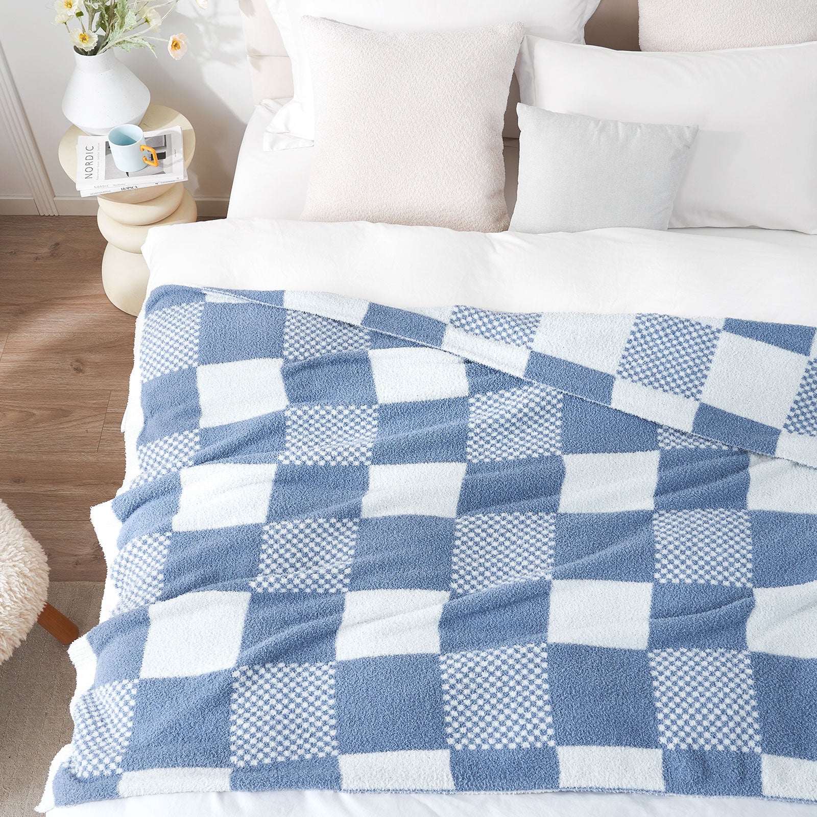 Blue and white checkered blanket on a bed with pillows and a wooden  nightstand.#color_Pale Blue